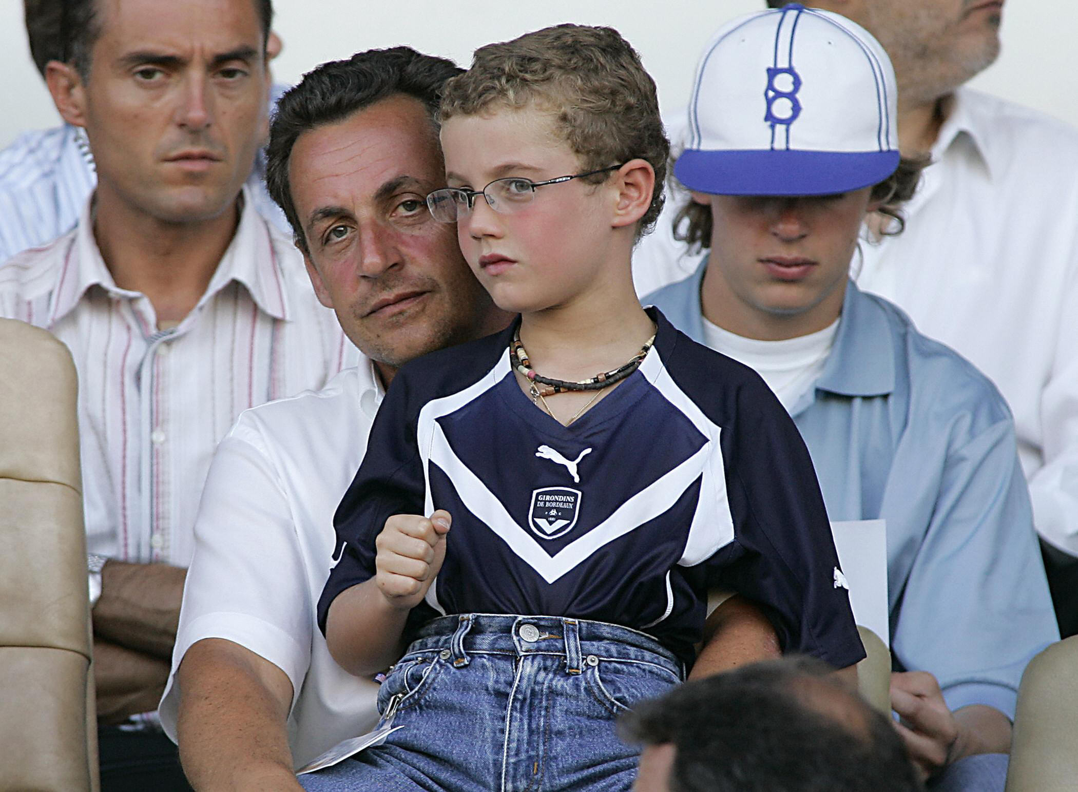 Le ministre français de l'Économie et des Finances, Nicolas Sarkozy, assiste avec son fils Louis au match de football de Ligue 1 entre Bordeaux et Nice, le 14 août 2004, au stade Chaban Delmas de Bordeaux I Source : Getty Images