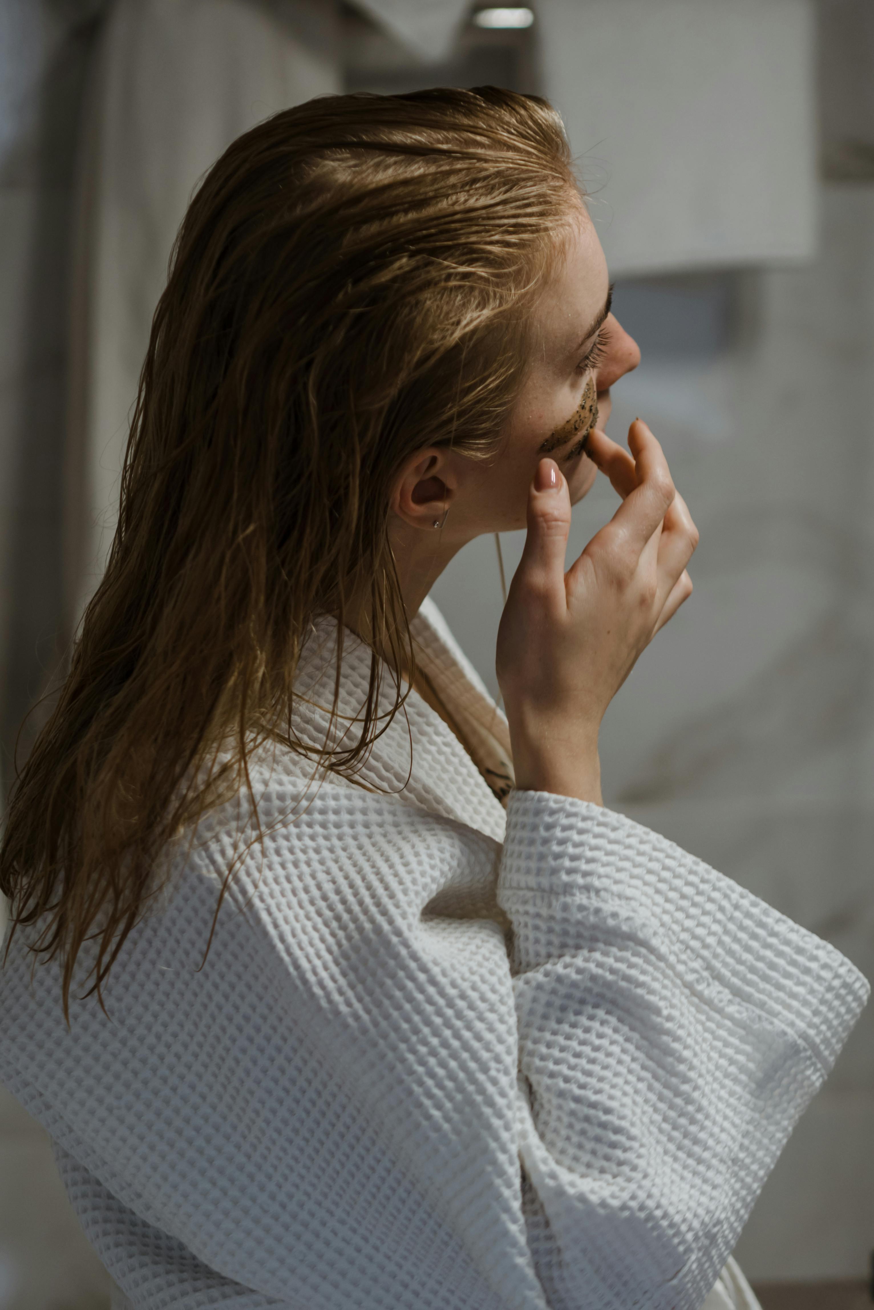 Une femme appliquant des produits pour le visage après avoir pris une douche | Source : Pexels