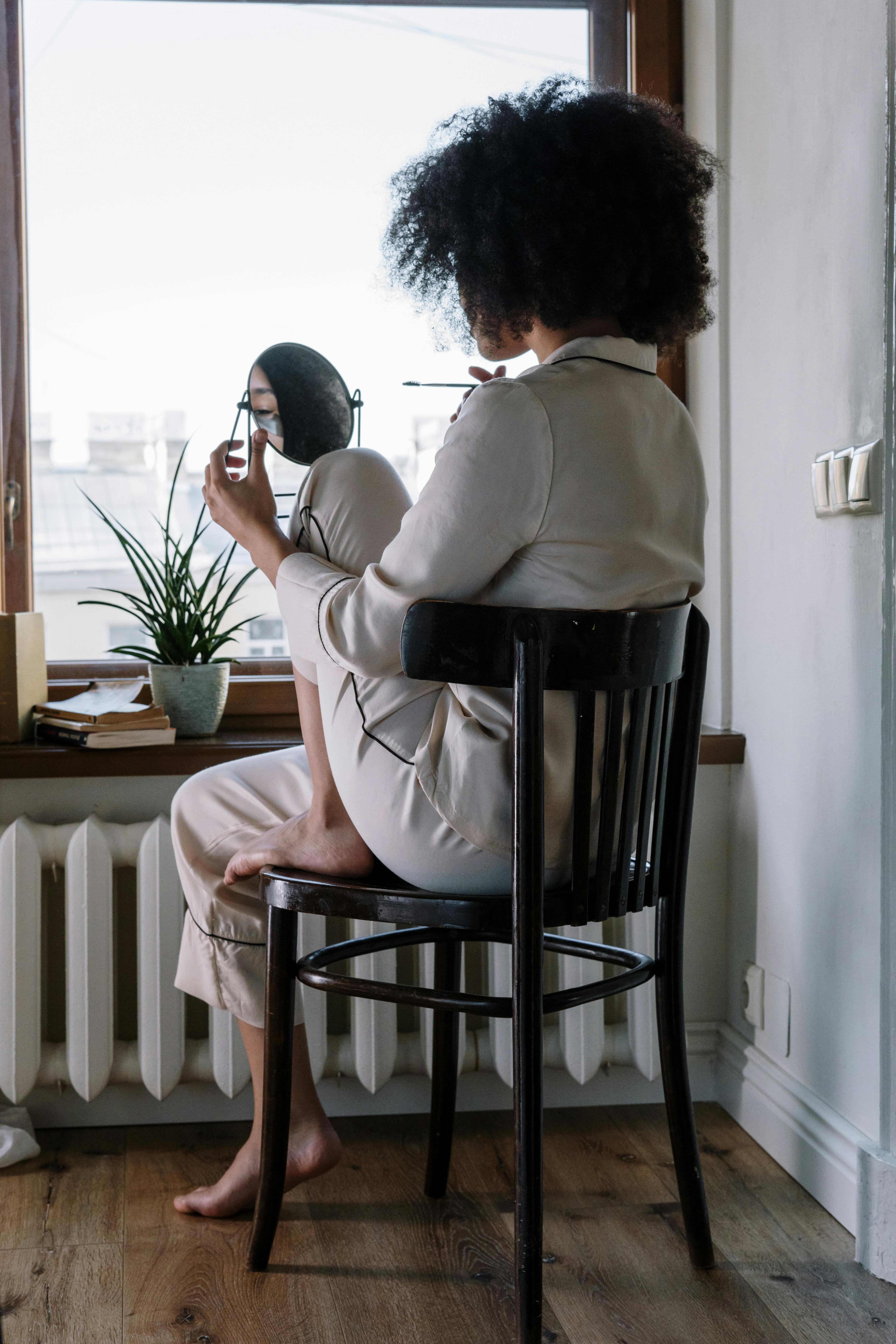 Une femme portant un pyjama tout en se regardant dans un miroir | Source : Pexels