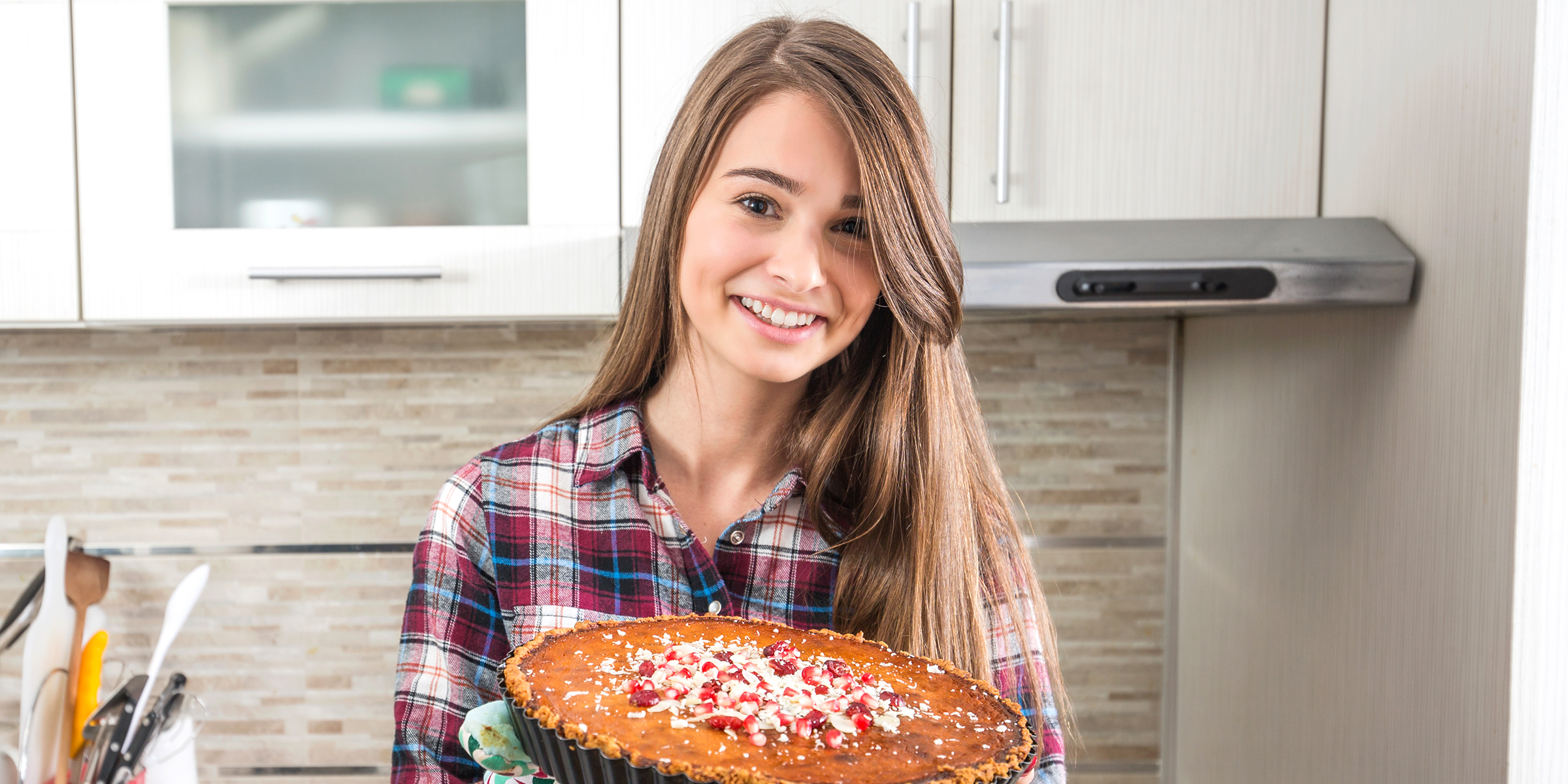 Une femme souriante qui tient une tarte | Source : Shutterstock