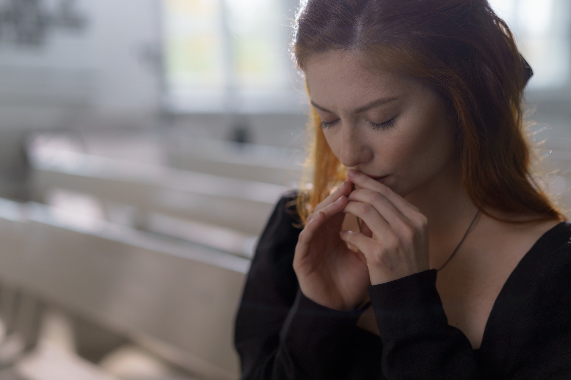 Una mujer rezando con los ojos cerrados | Fuente: Pexels