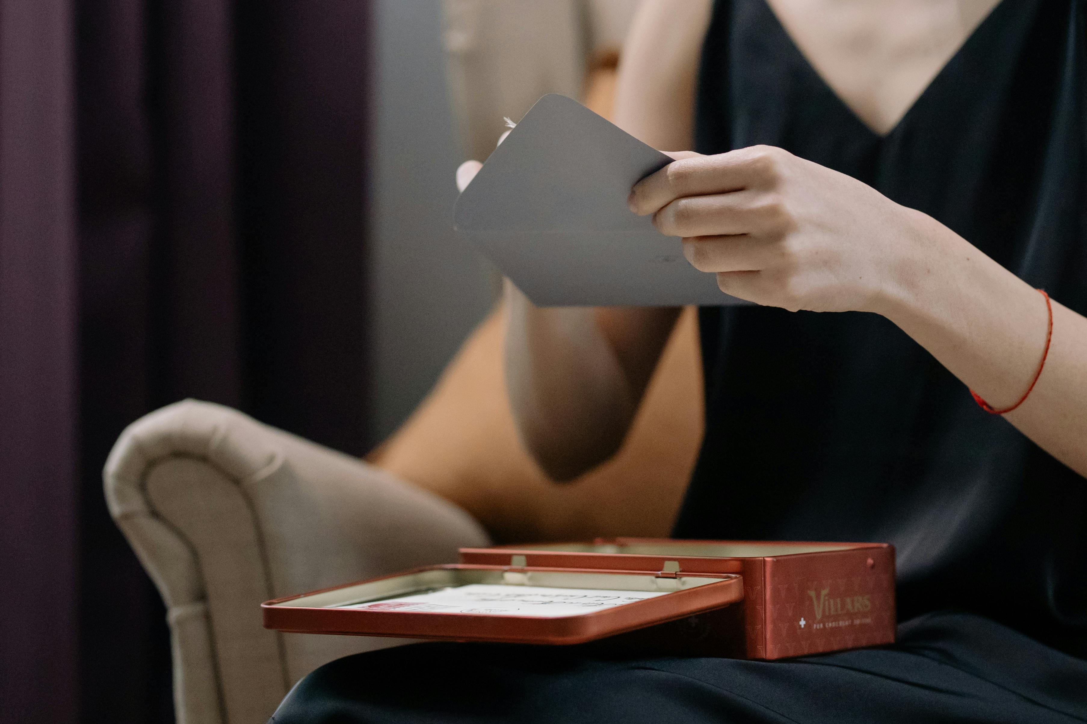 Une femme ouvrant une enveloppe grise | Source : Pexels