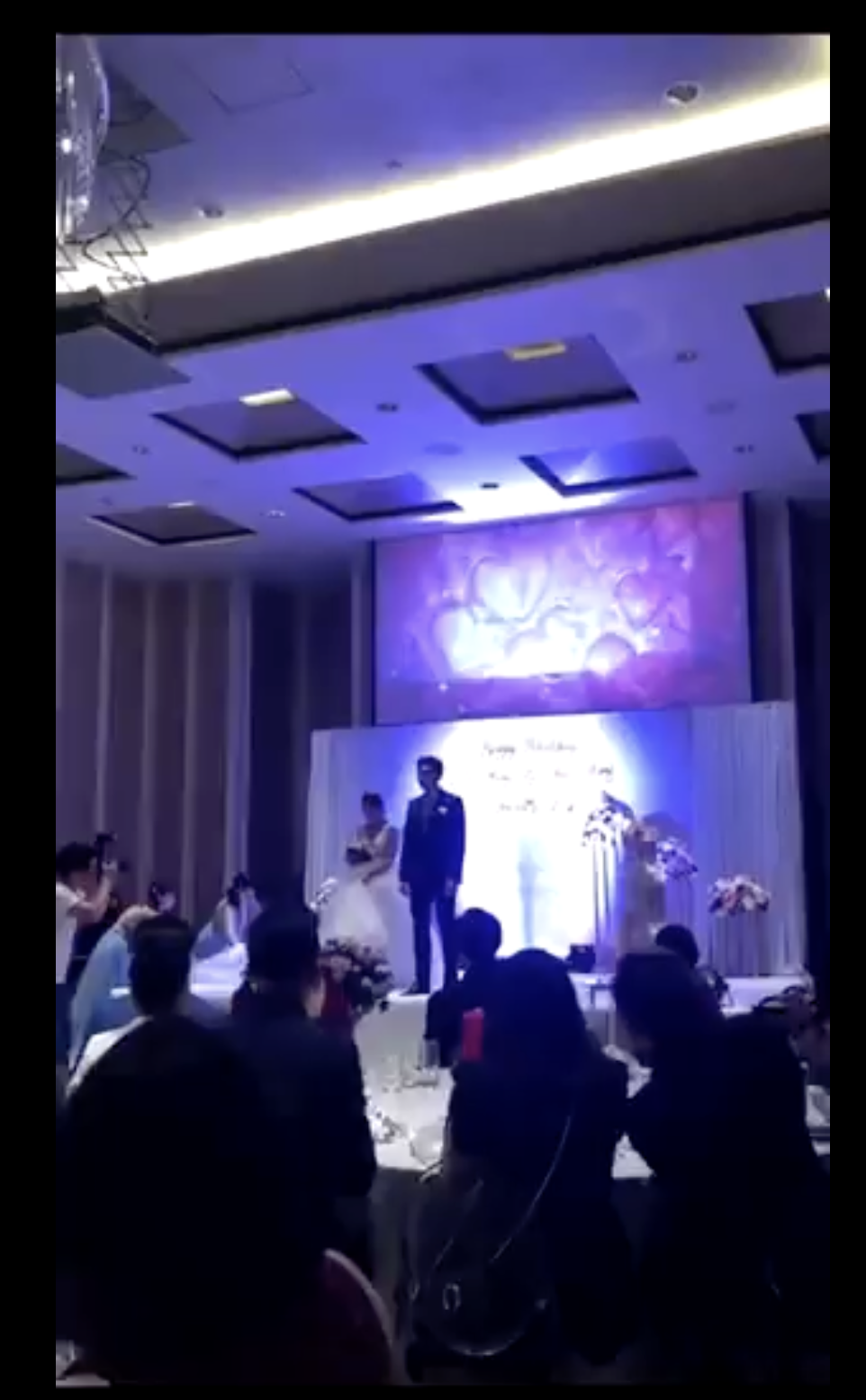 Les jeunes mariés sont photographiés ensemble sur la scène. | Source : twitter.com/TuanConCom1