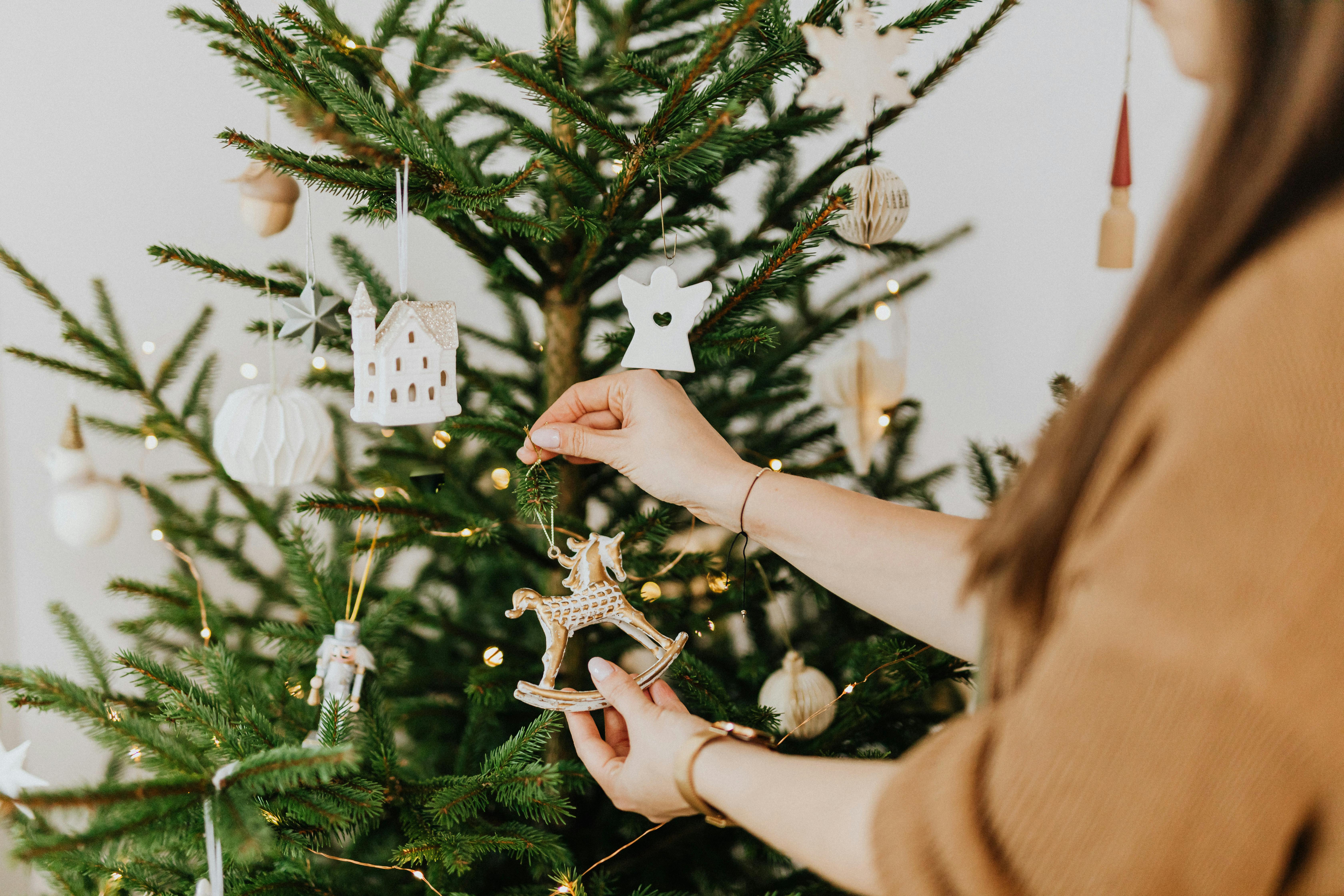 Une femme décorant un arbre de Noël | Source : Pexels