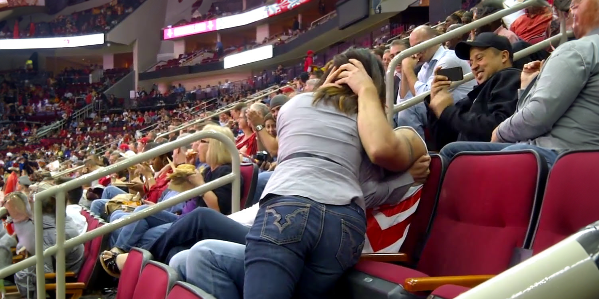 Mulher beija um homem no estádio | Shutterstock