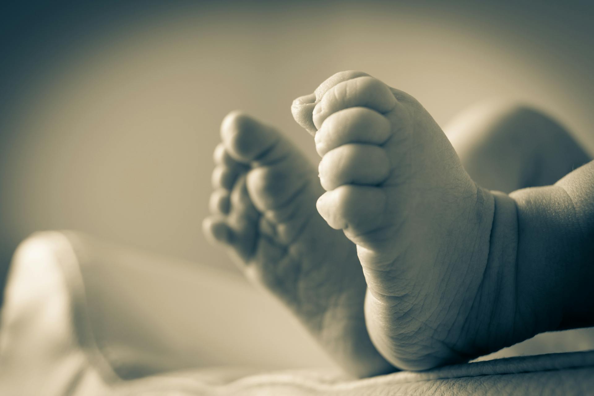 Une photo en niveaux de gris des pieds d'un nouveau-né | Source : Pexels