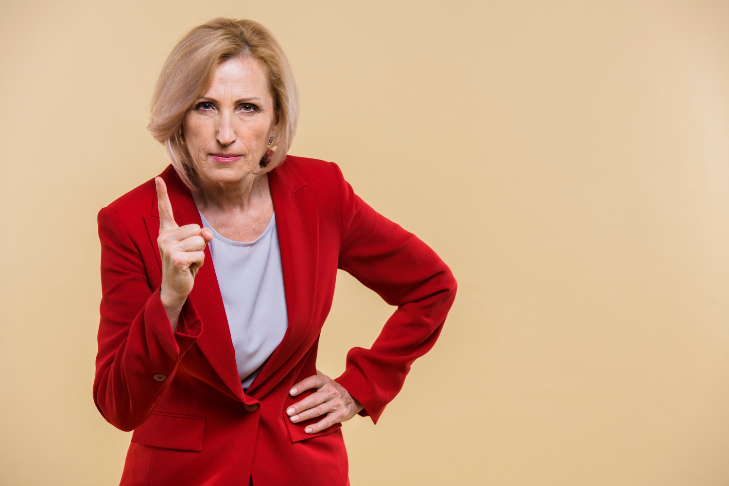 Une femme âgée sérieuse qui pointe son doigt | Source : Freepik