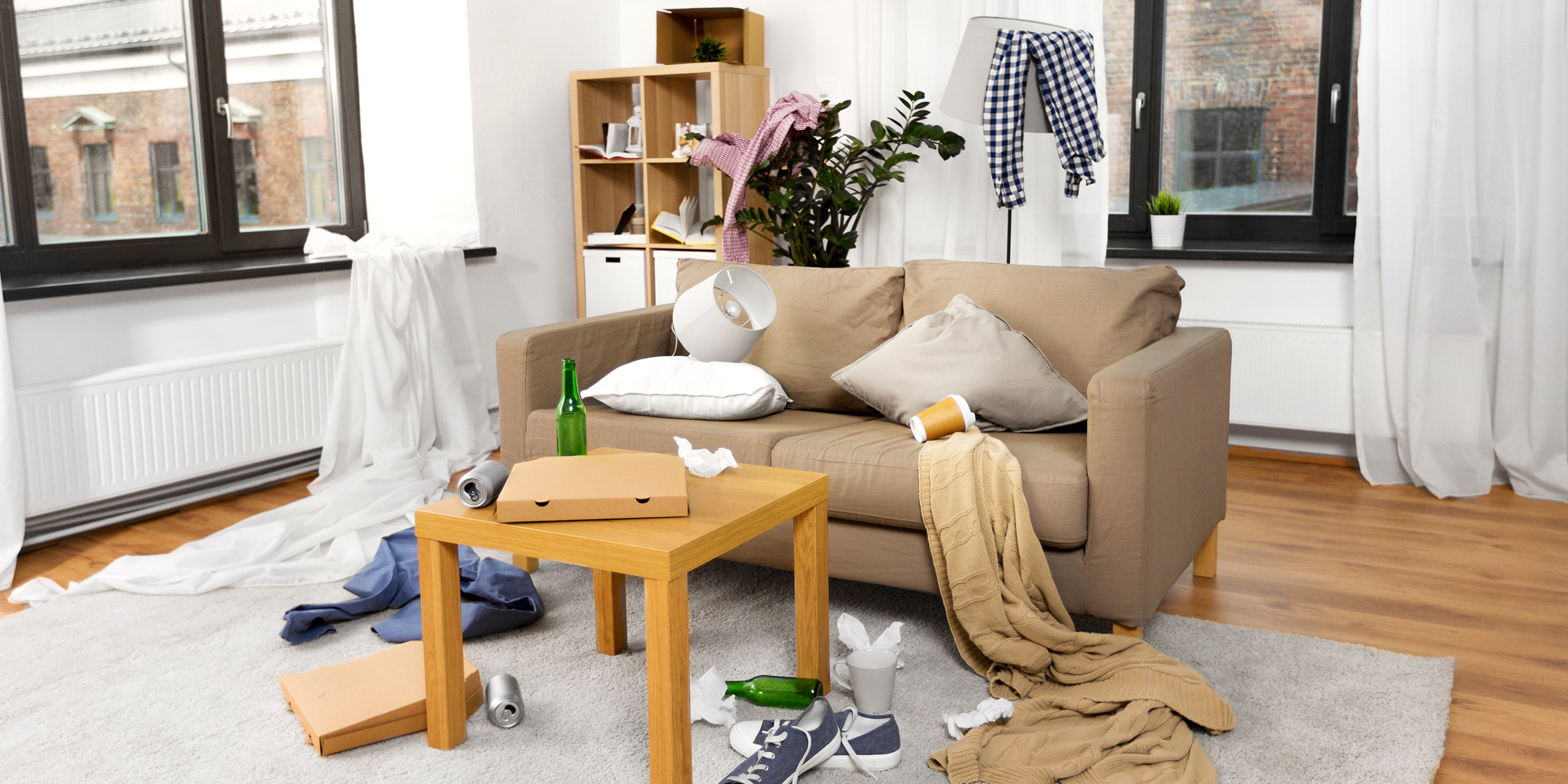 Un salon en désordre avec des boîtes à emporter, des vêtements et des déchets éparpillés | Source : Shutterstock