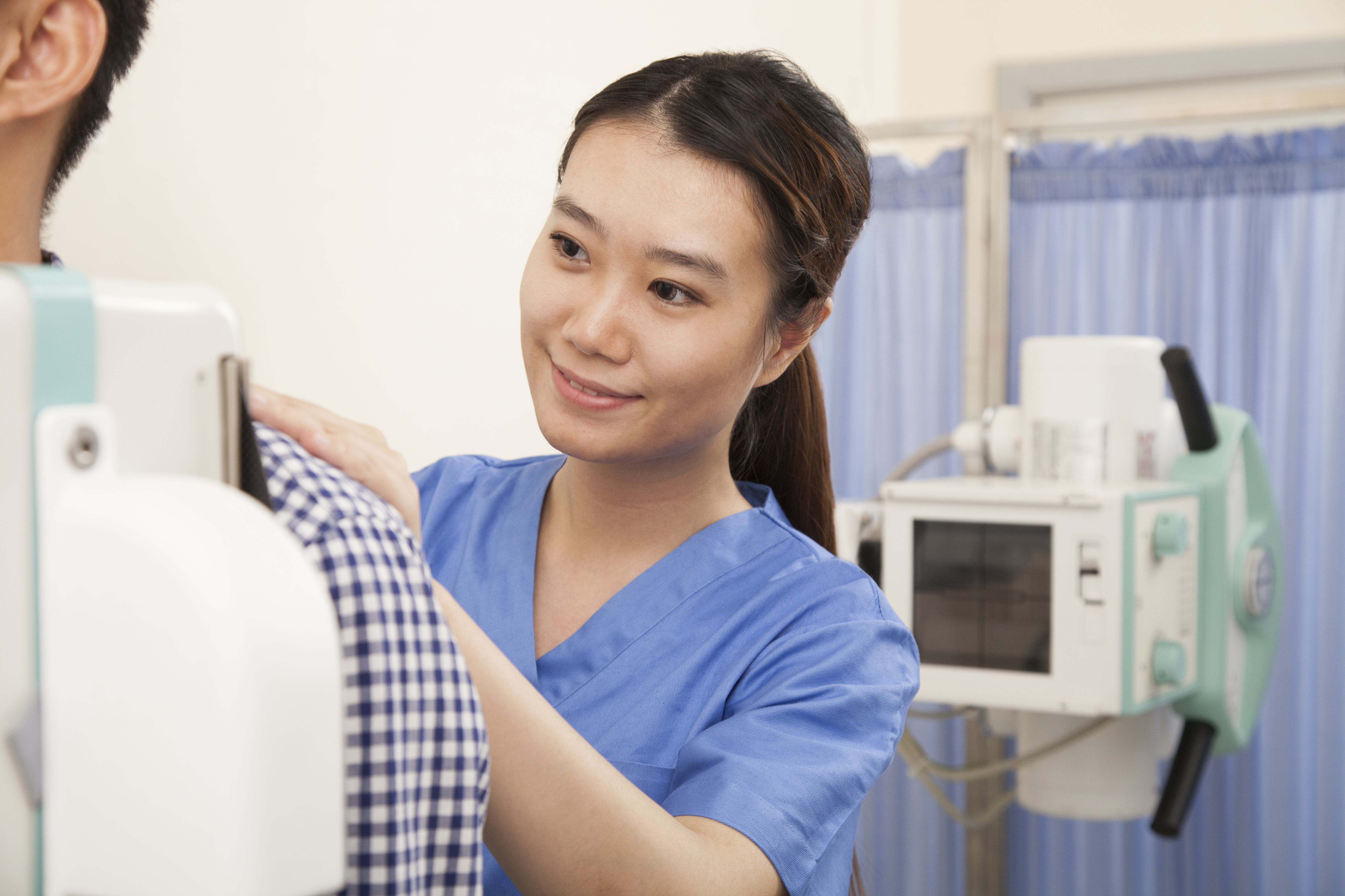Une femme médecin examine un patient de sexe masculin. | Source : Shutterstock