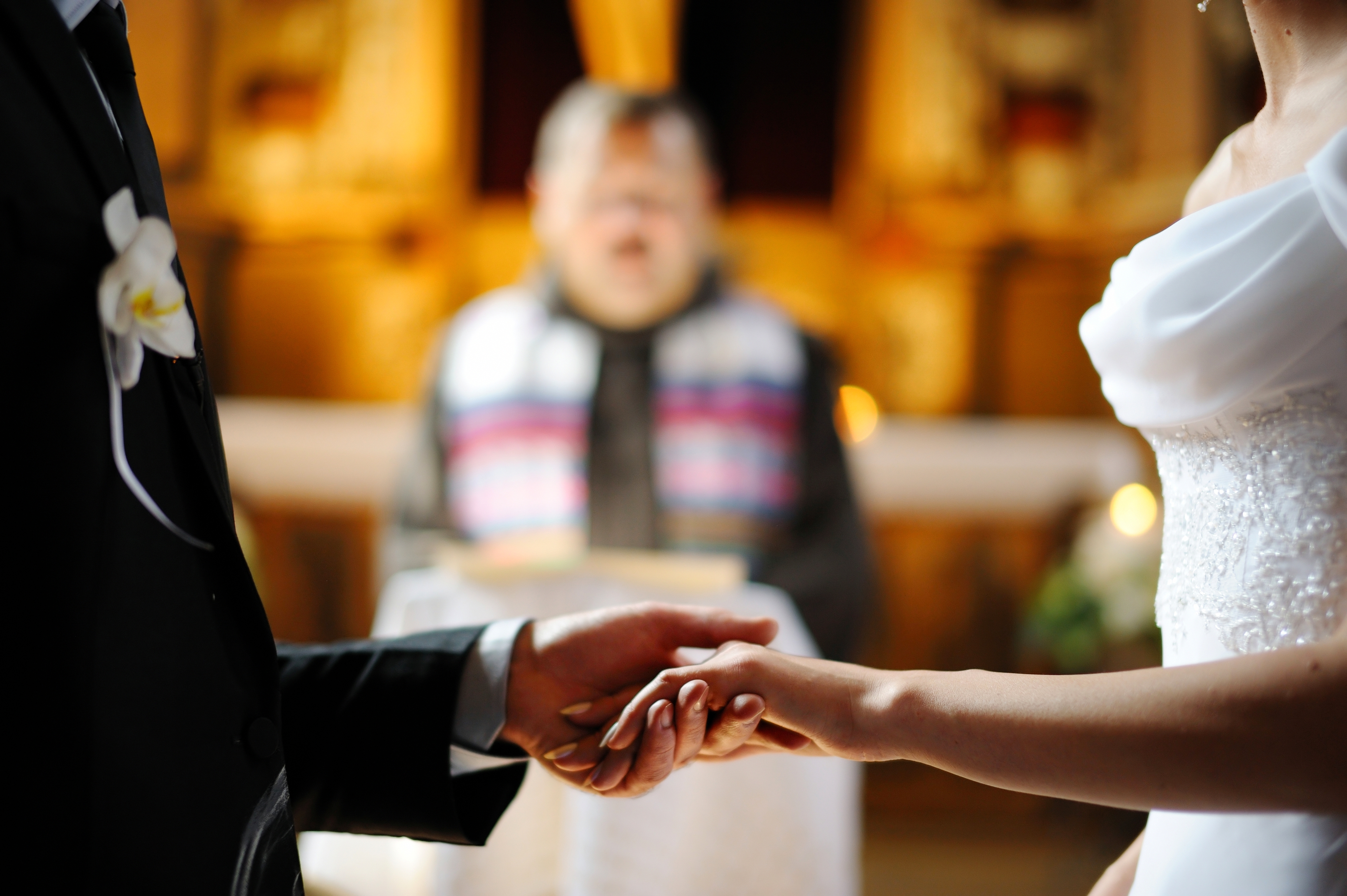 Une mariée et un marié se tenant la main pendant la cérémonie de mariage | Source : Shutterstock