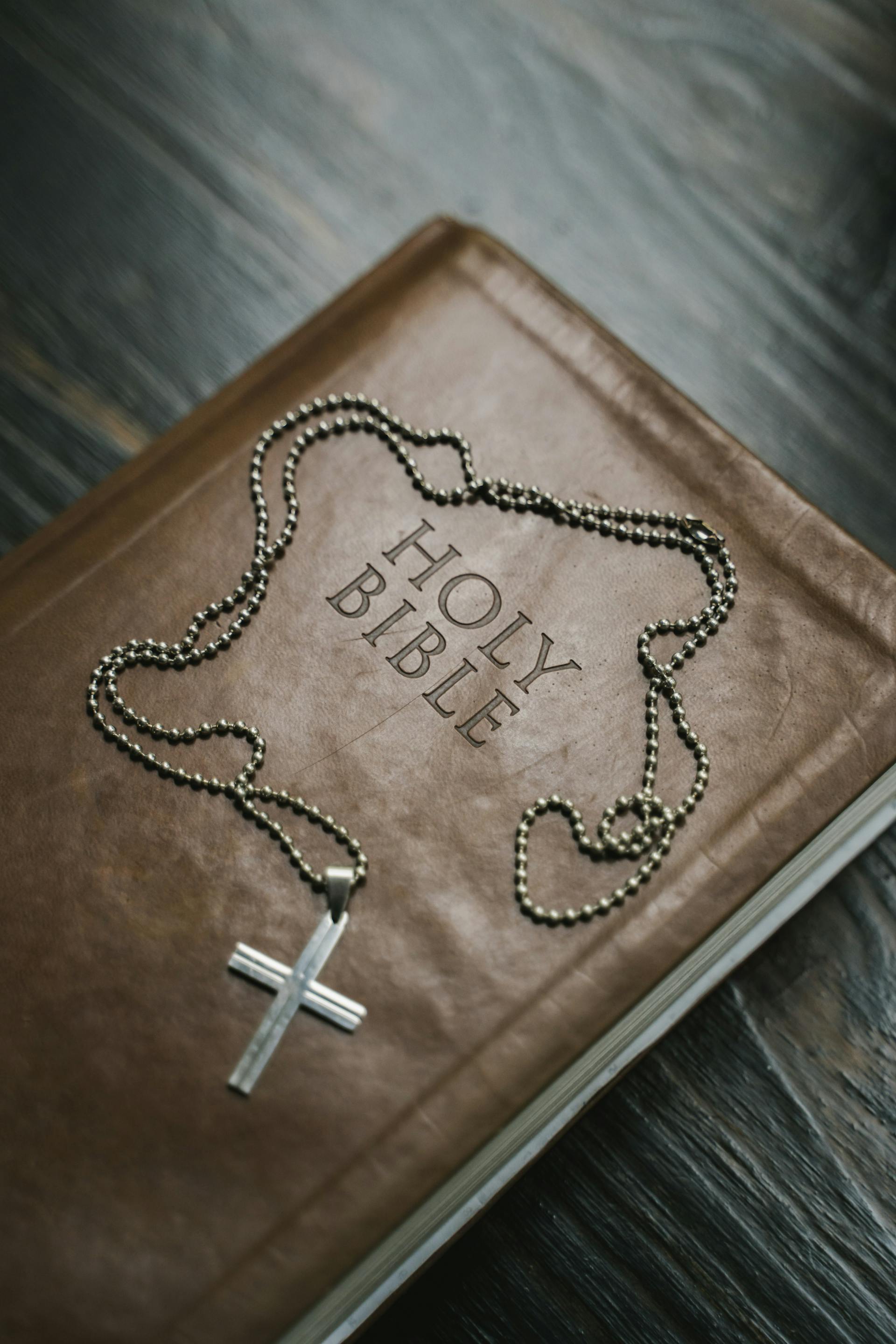 Une bible et un collier de croix en argent | Source : Pexels
