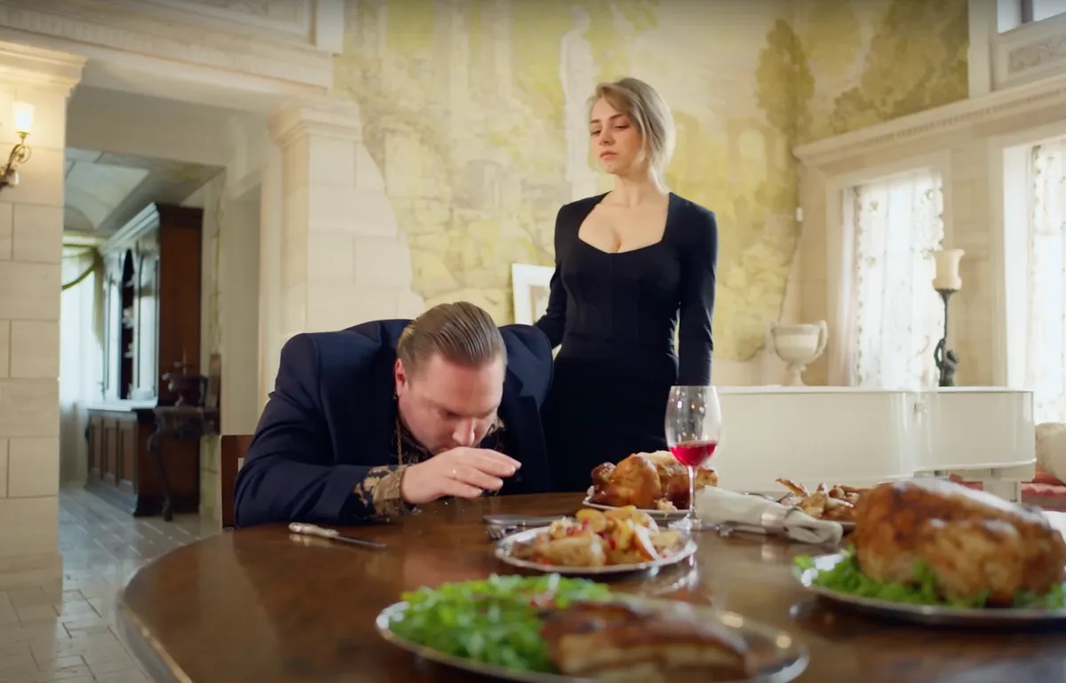 Une femme se tient debout près d'un homme en train de dîner | Source : Youtube/LOVEBUSTER