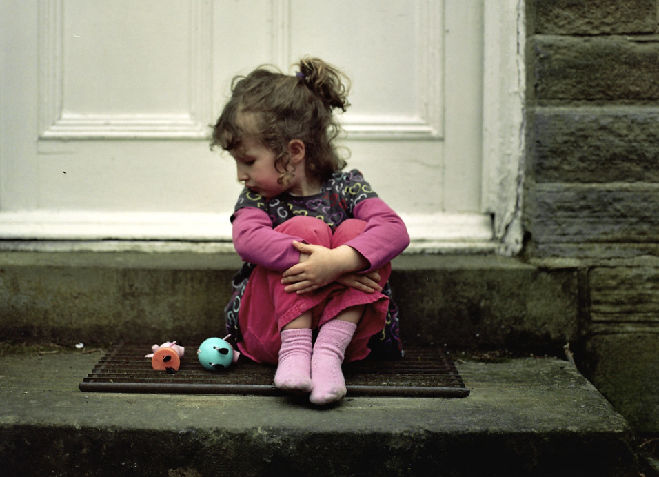 Menina na porta de uma casa | Fonte: Shutterstock