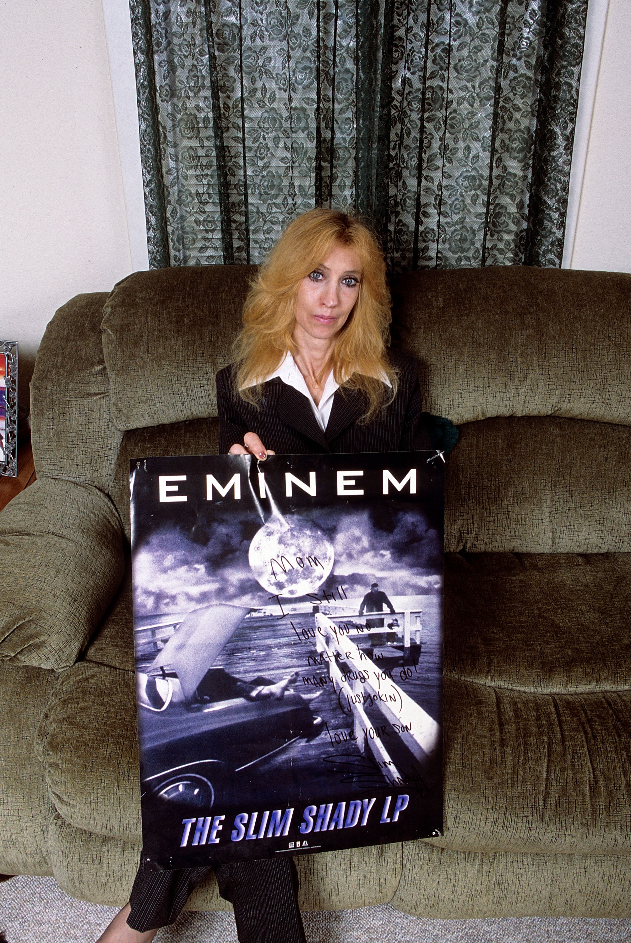 La mère d'Eminem, Debbie Nelson, tient une affiche, lors d'une séance photo chez elle en septembre 2005 à Detroit, dans le Michigan. | Source : Getty Images