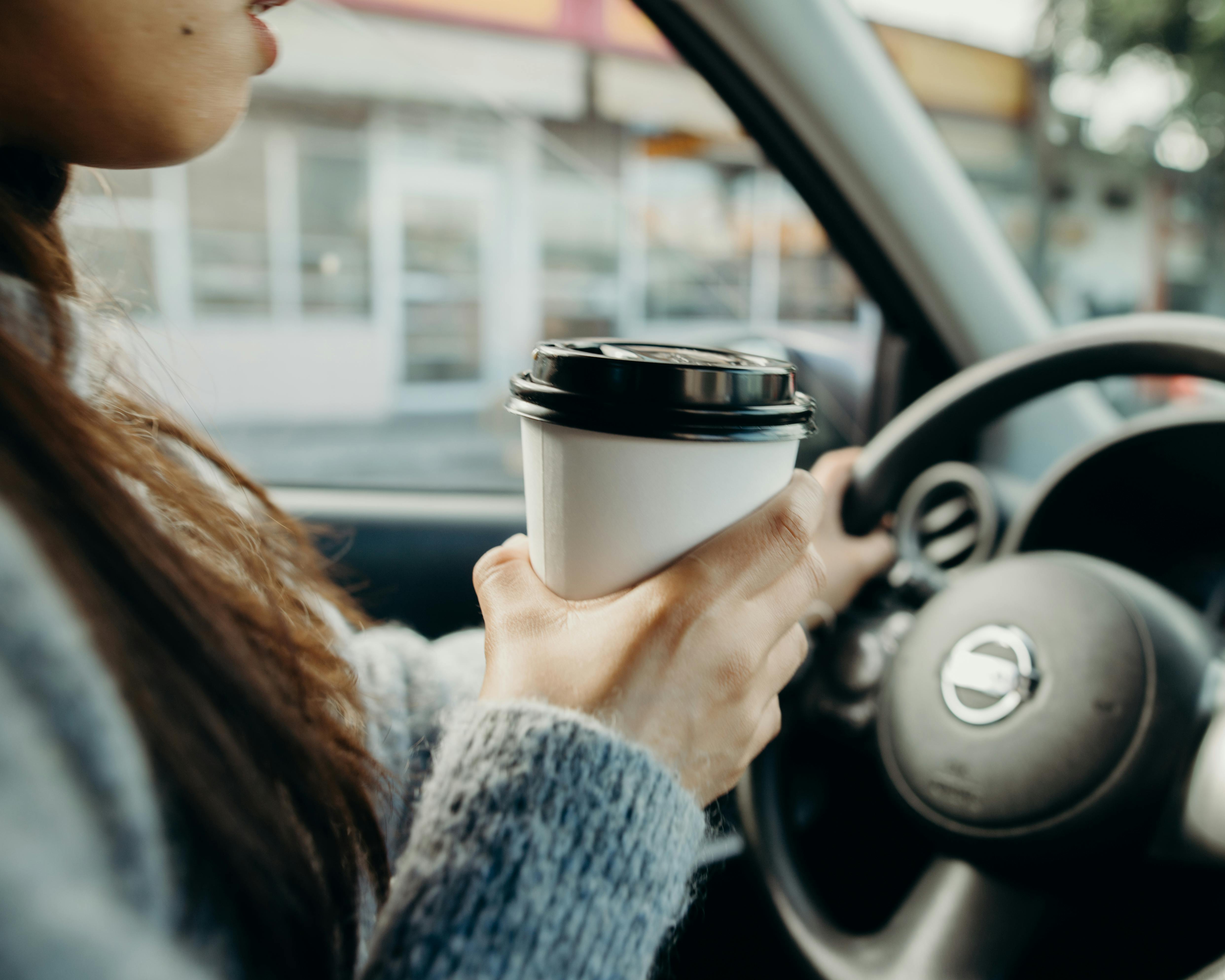 Une femme qui conduit en tenant un café | Source : Pexels