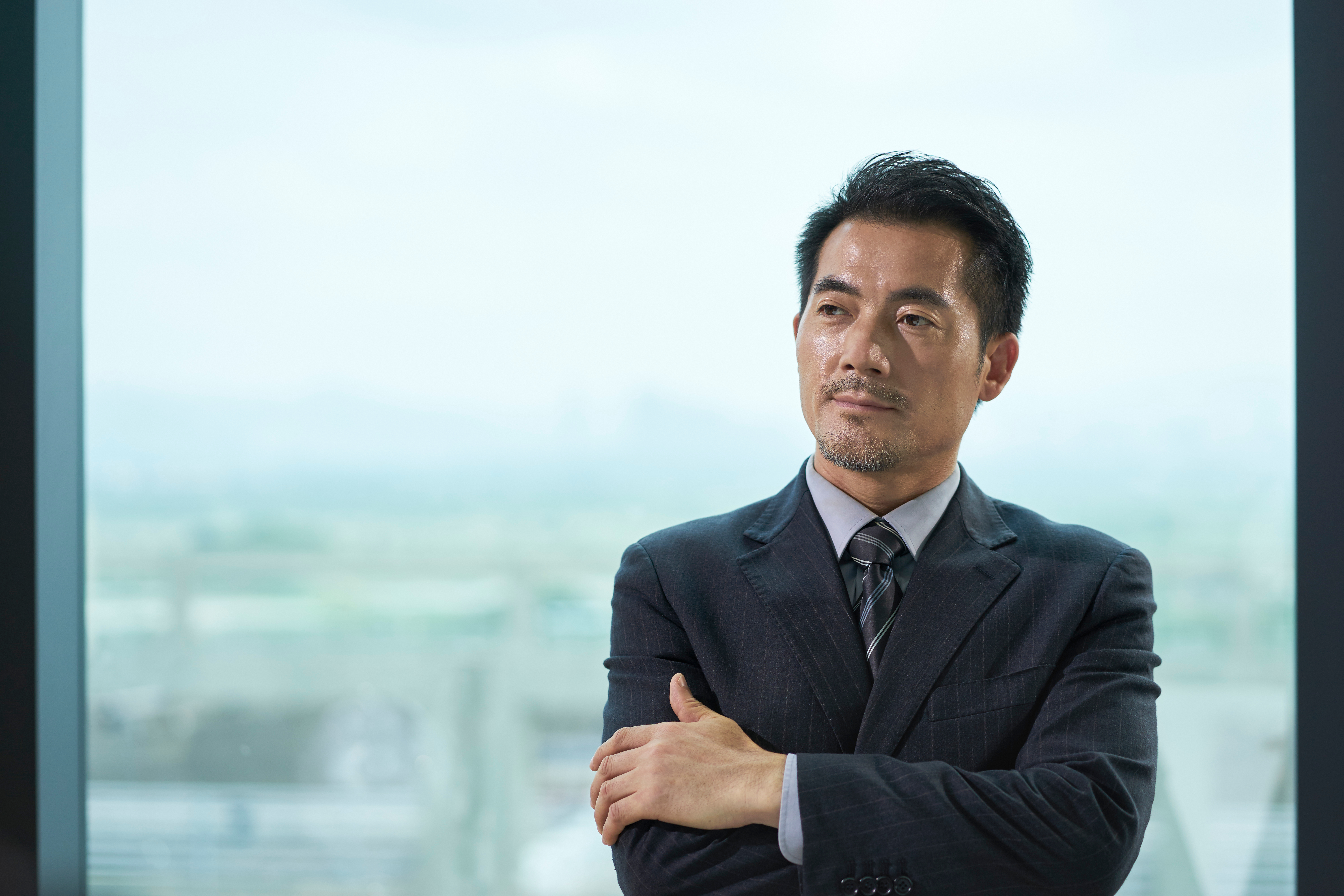 Un homme d'affaires coréen debout dans son bureau | Source : Shutterstock