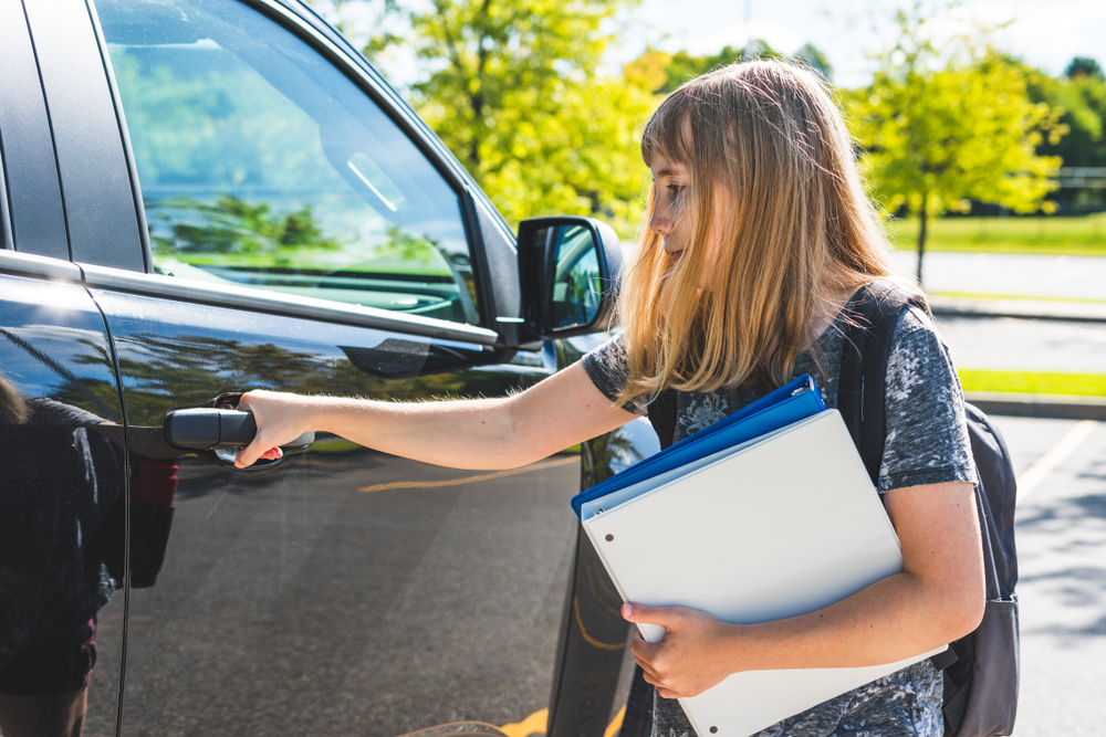 Une adolescente debout à côté d'une voiture | Source : Shutterstock