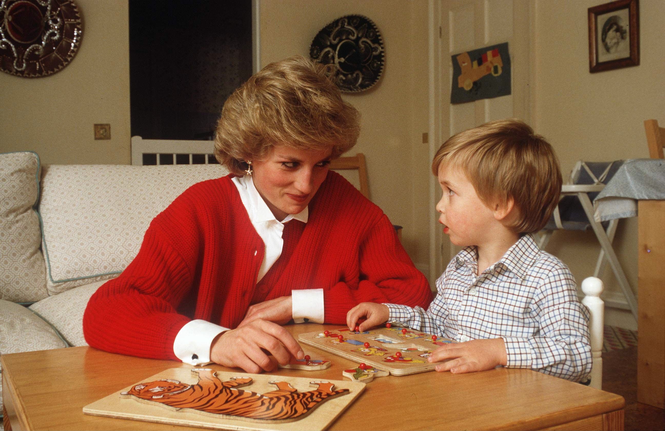 La princesse Diana aide le prince William avec un puzzle dans sa salle de jeux au palais de Kensington. | Source : Getty Images       