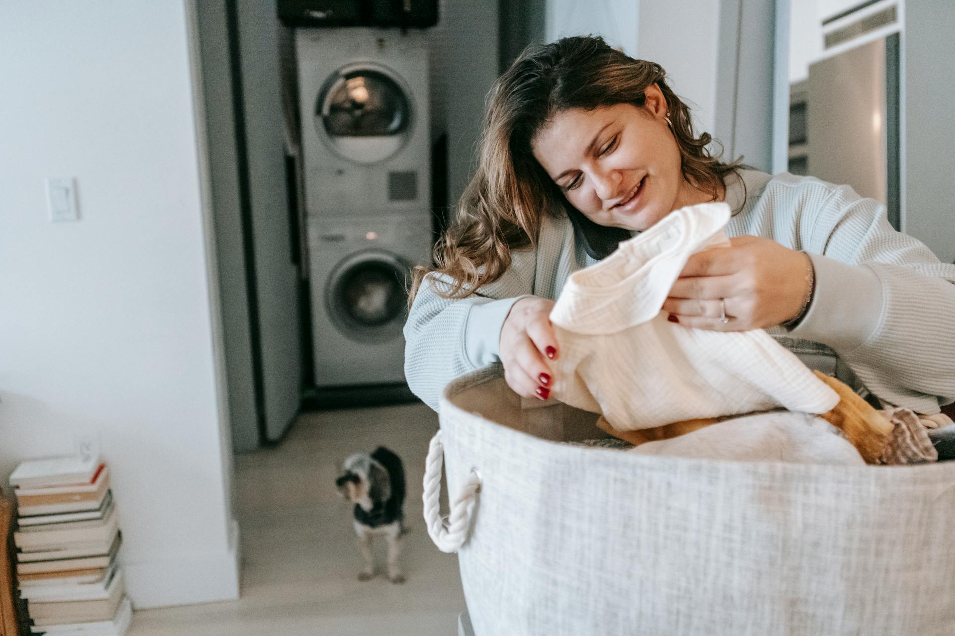Une femme sourit avec espoir tout en pliant des vêtements | Source : Pexels