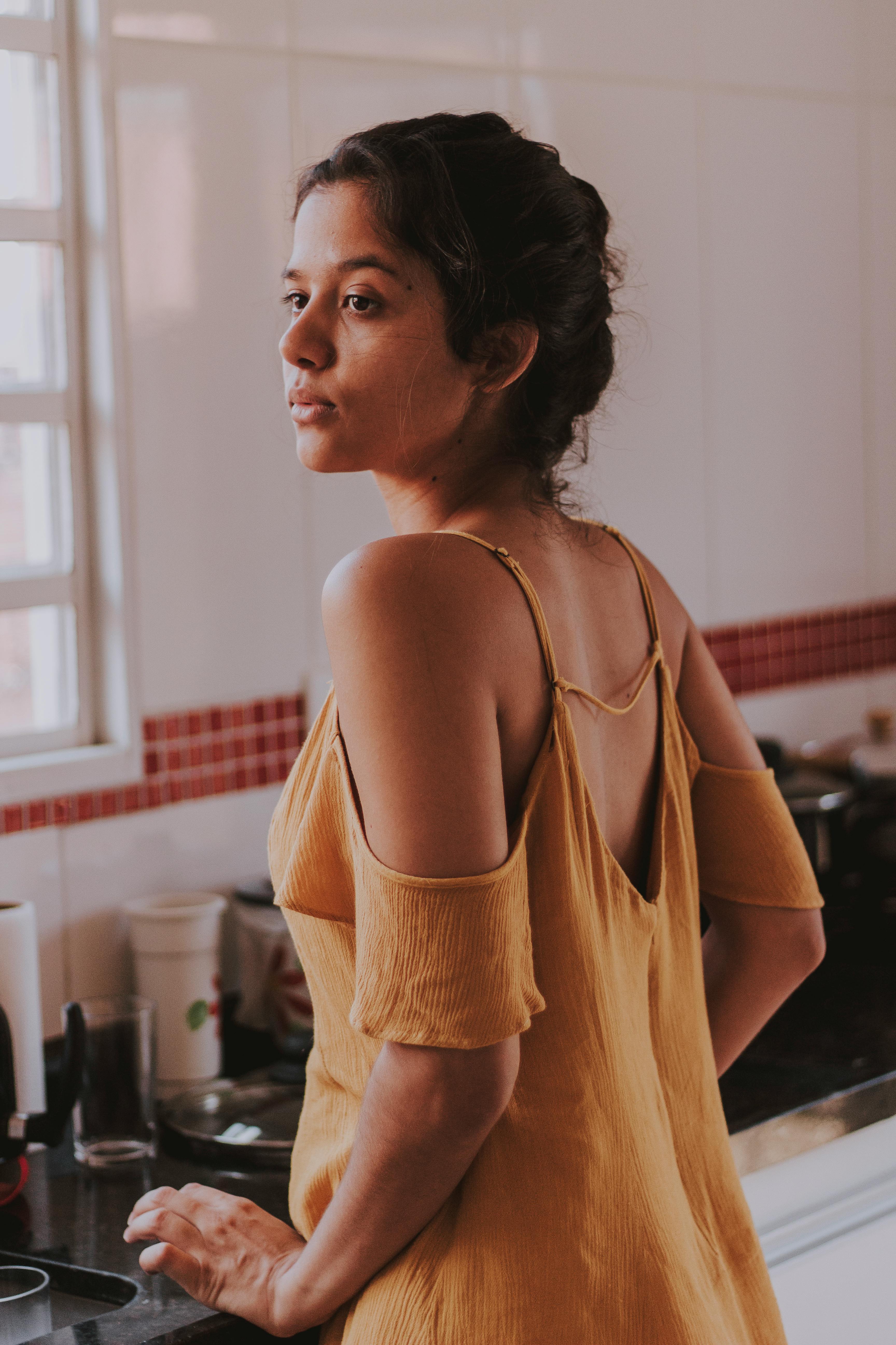 Une femme a l'air contrariée alors qu'elle se tient dans la cuisine | Source : Pexels