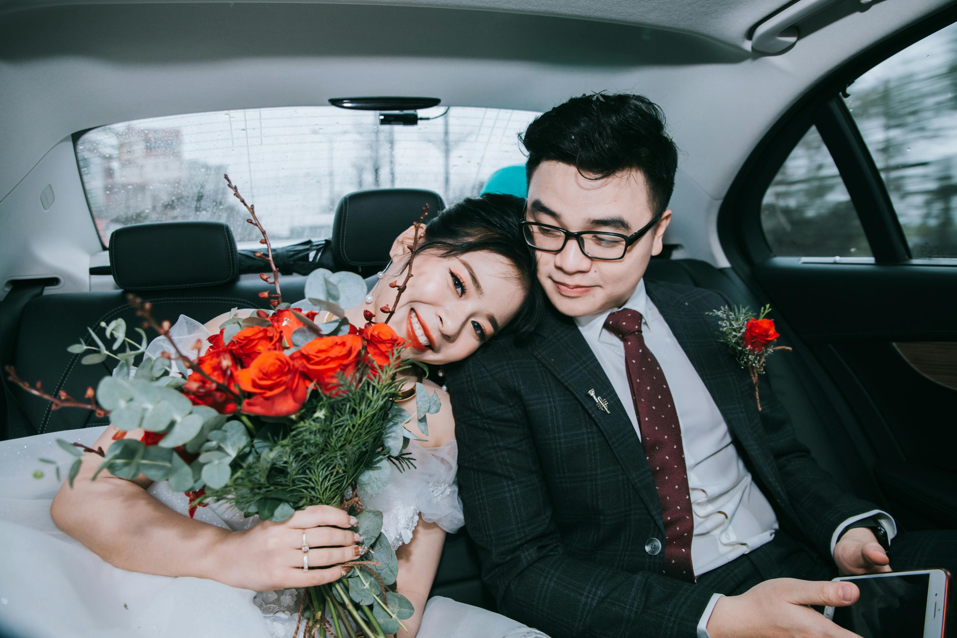 Couple de jeunes mariés heureux dans une voiture | Source : Pexels