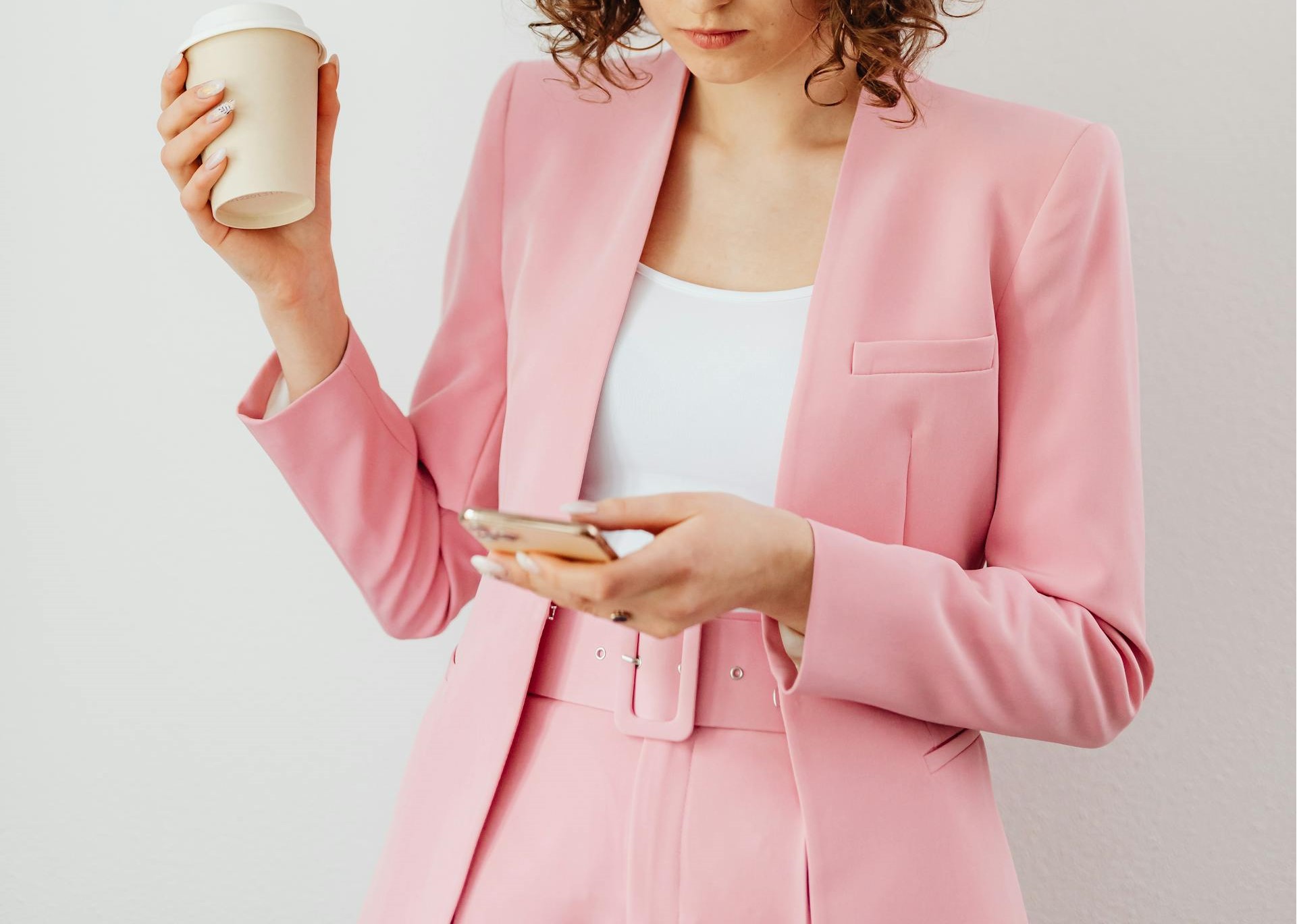 Une femme portant des vêtements roses tenant un smartphone | Source : Pexels