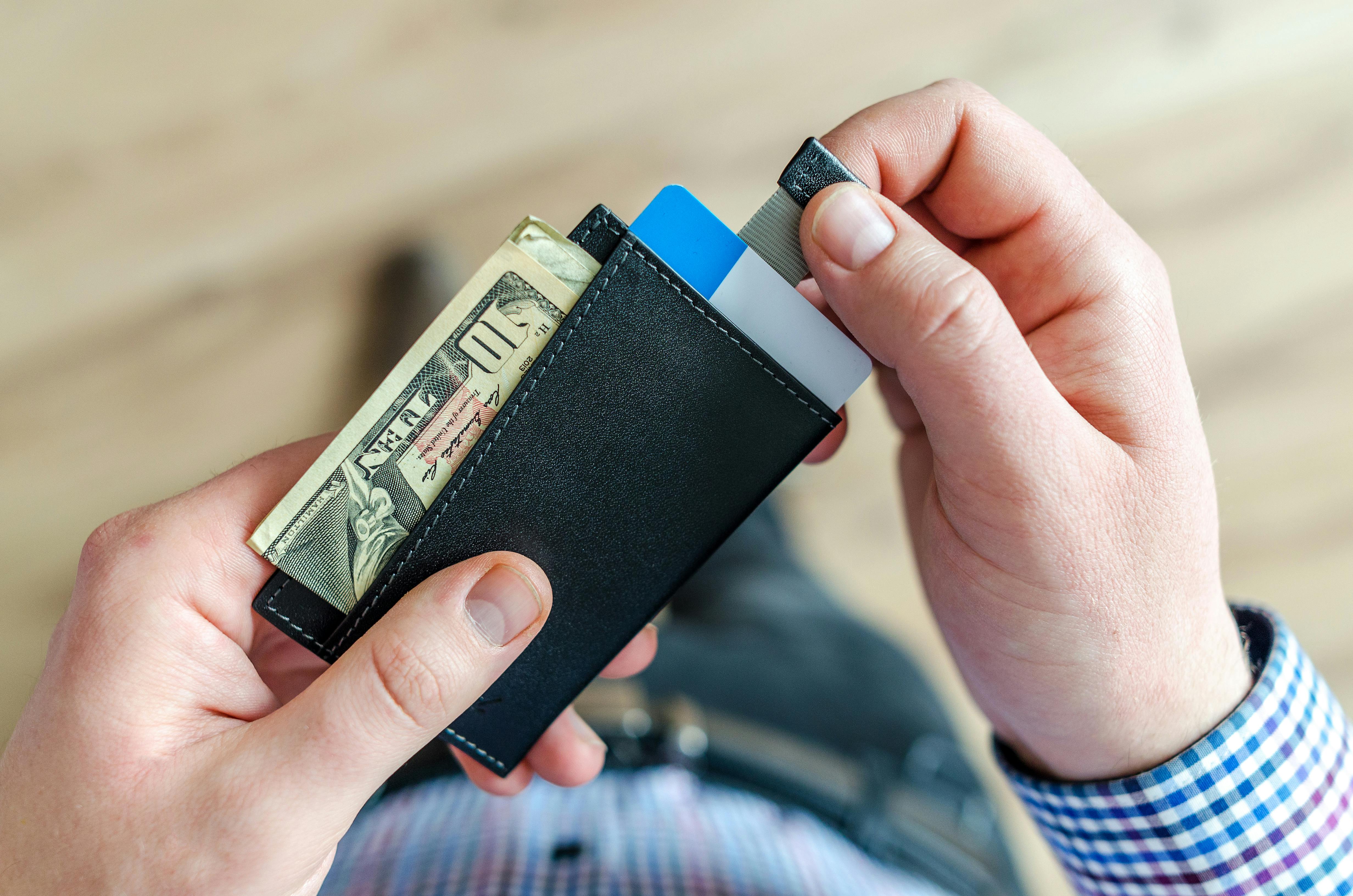 Un homme qui sort des billets de son portefeuille | Source : Pexels