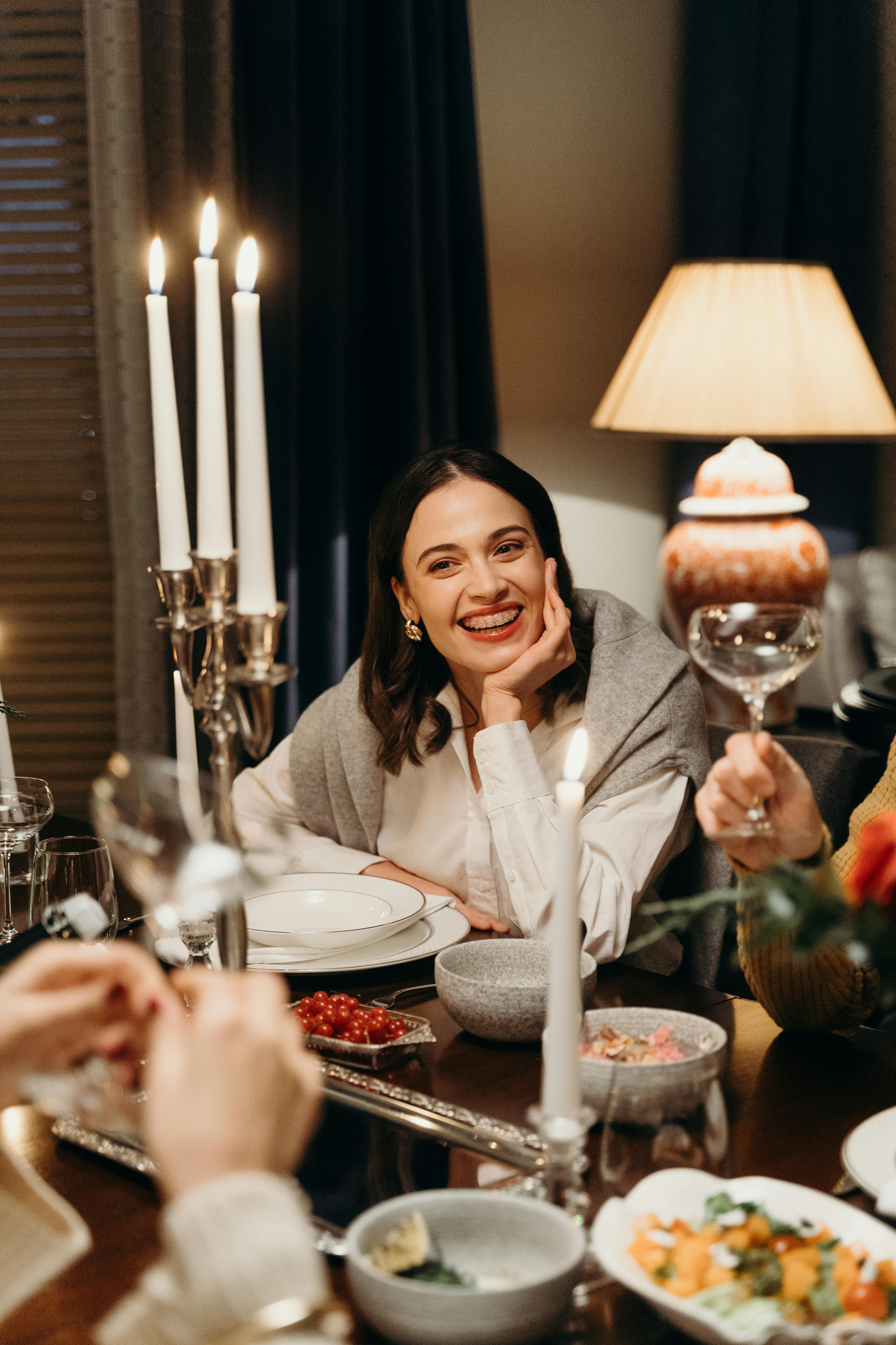 Une femme souriante à la table du dîner | Source : Pexels