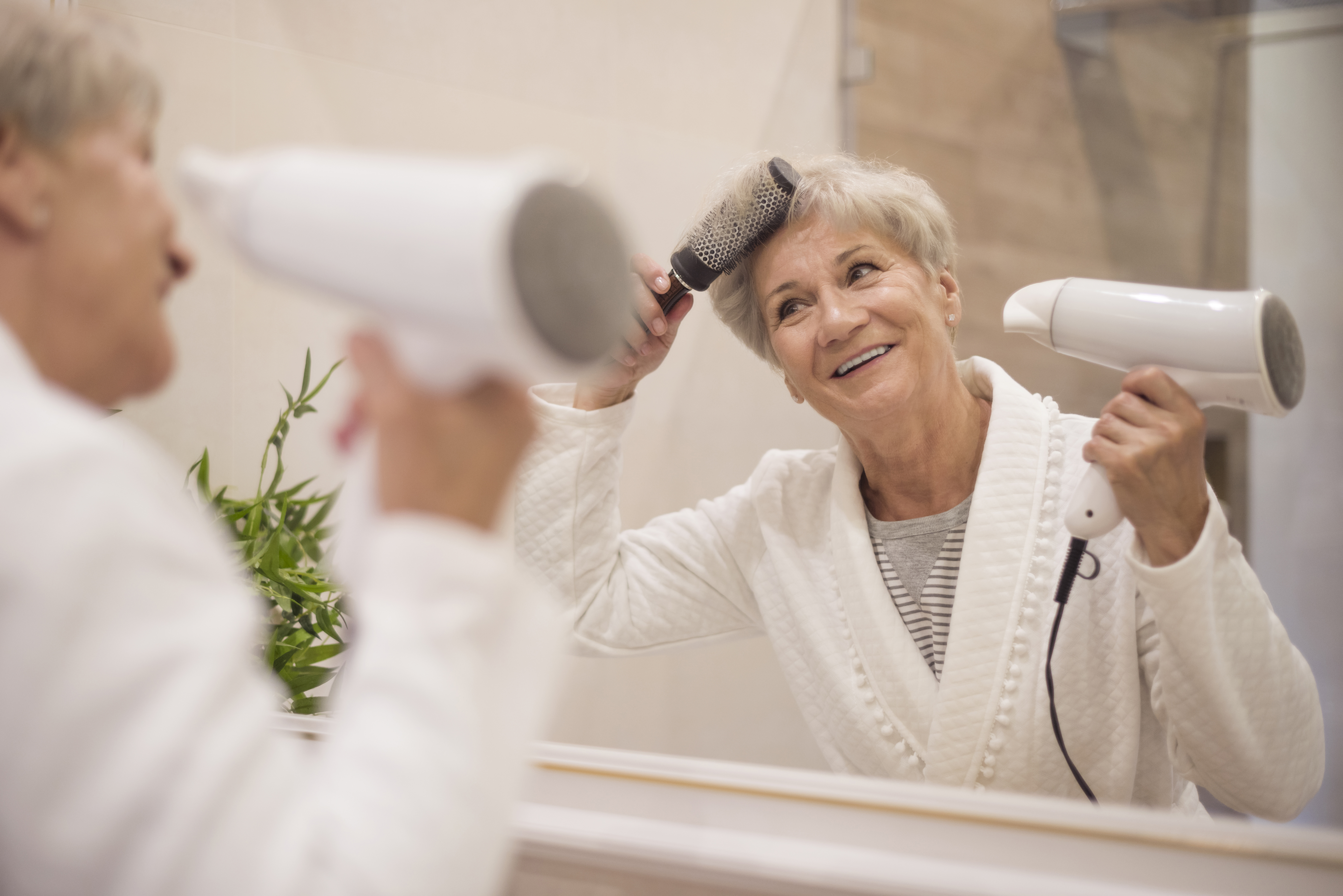 Une grand-mère qui se sèche les cheveux. | Source : Freepik