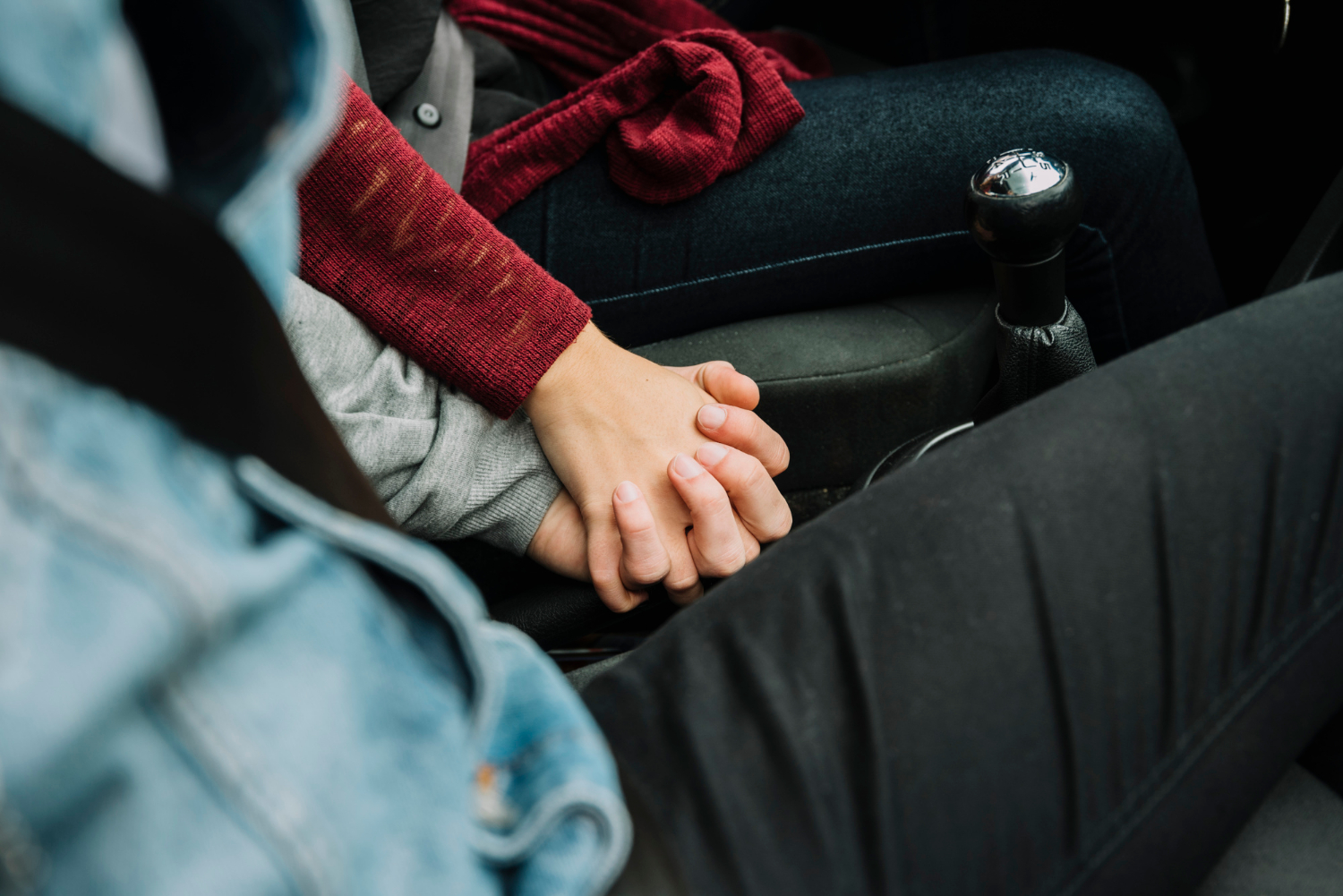 Un couple assis dans la voiture et se tenant par la main | Source : Freepik
