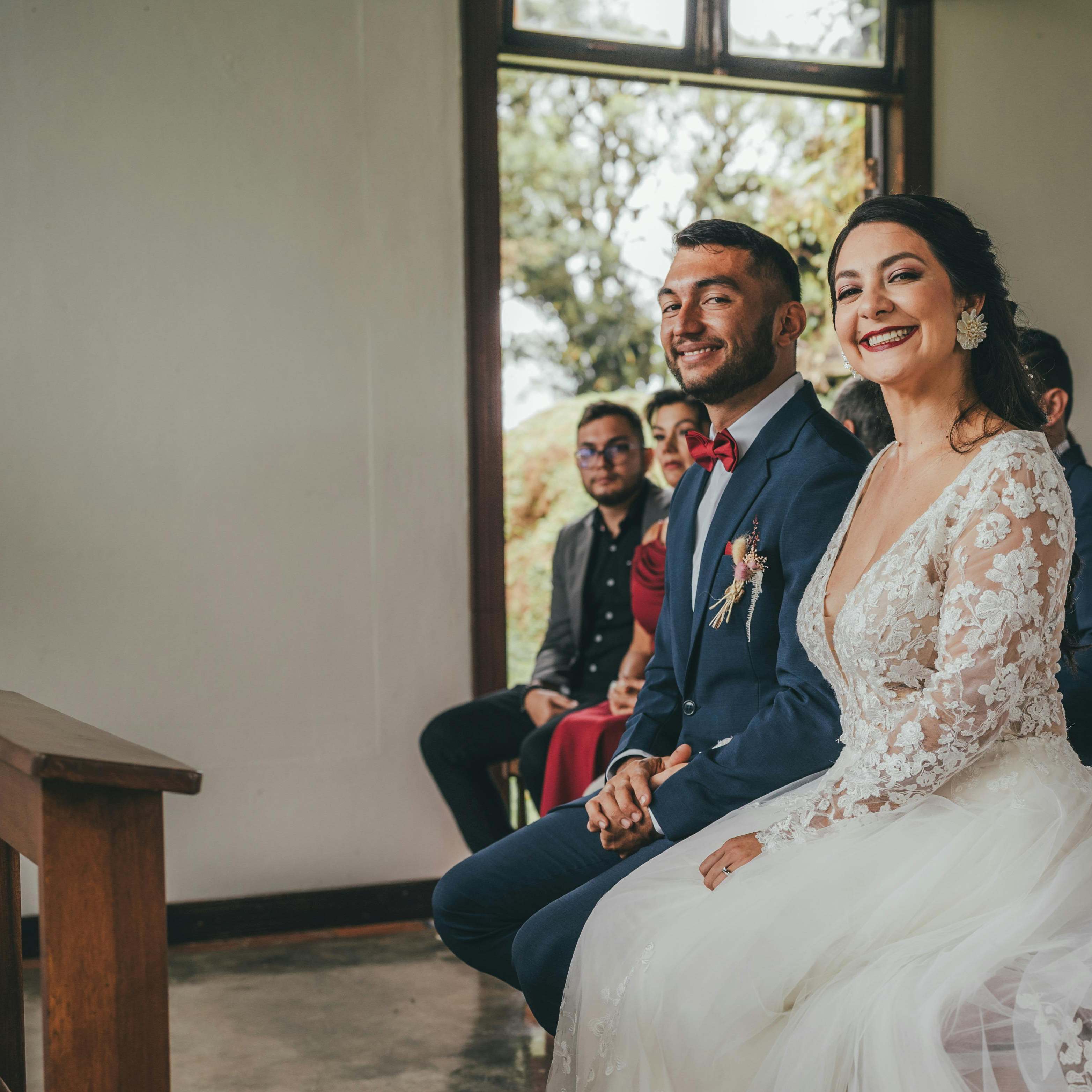 Une mariée et un marié souriant devant l'autel | Source : Pexels