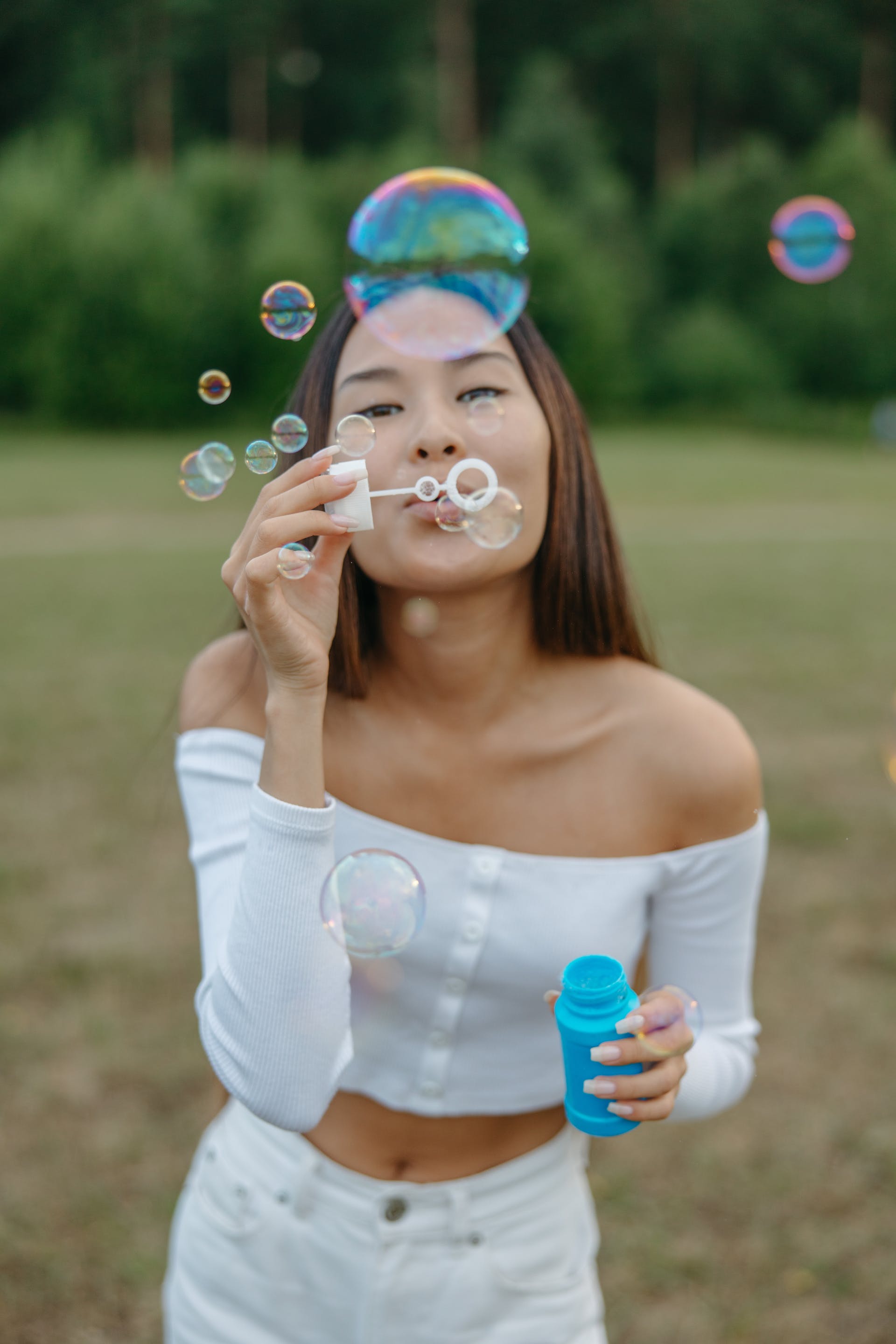 Una mujer soplando burbujas | Fuente: Pexels