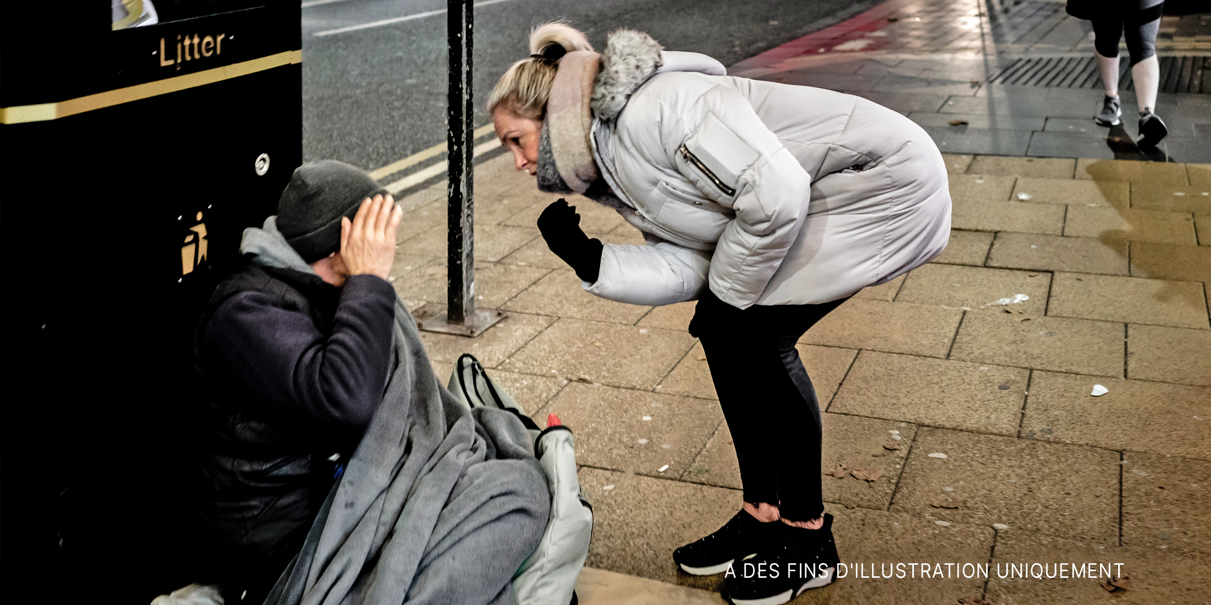 Une femme d'âge moyen regardant un mendiant dans la rue. | Source : Flickr/Ian Livesey (Domaine public)