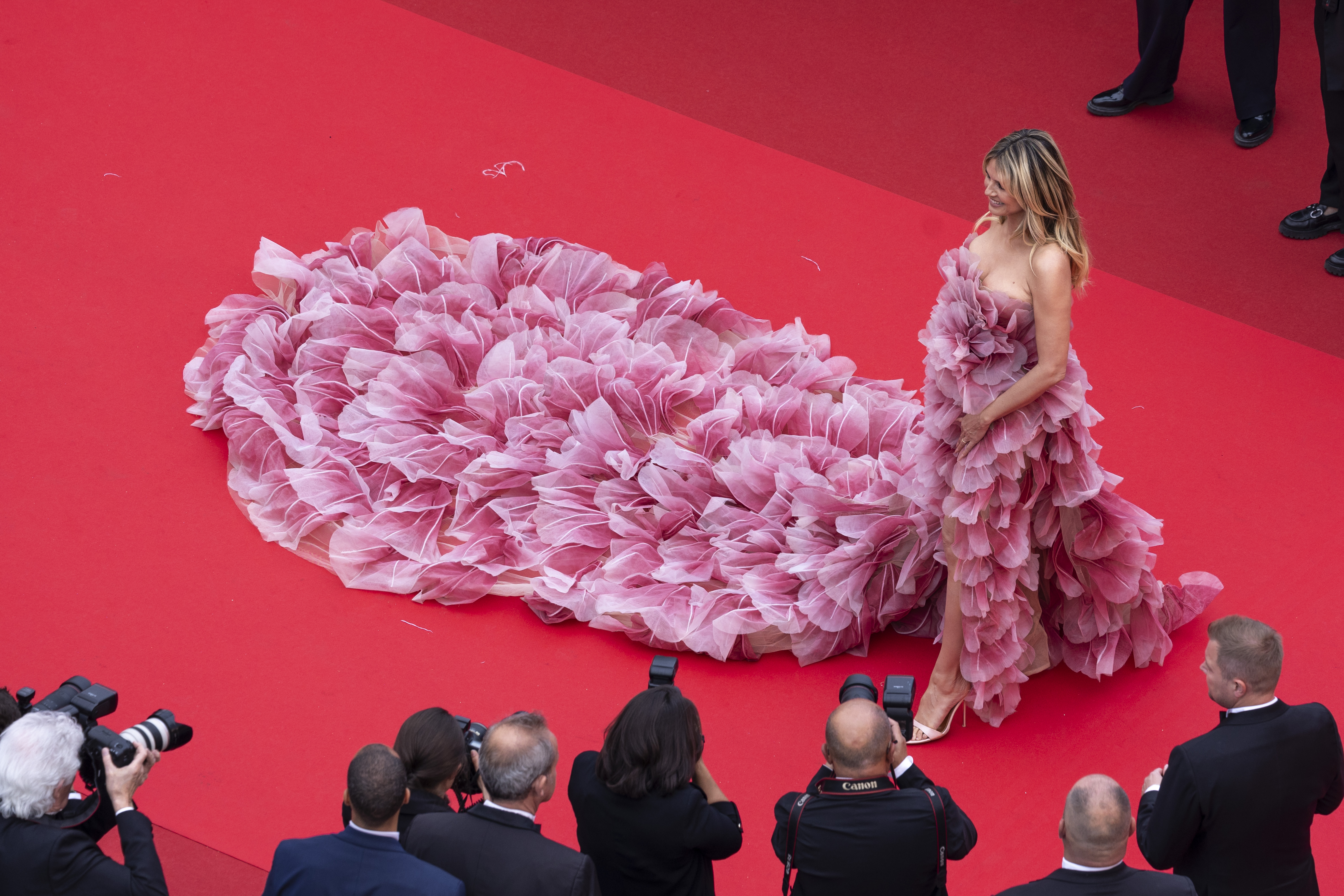 Un plan aérien offre une vue saisissante de la robe de Heidi Klum vue d'en haut, révélant subtilement son décolleté dans le cadre de l'encolure complexe.