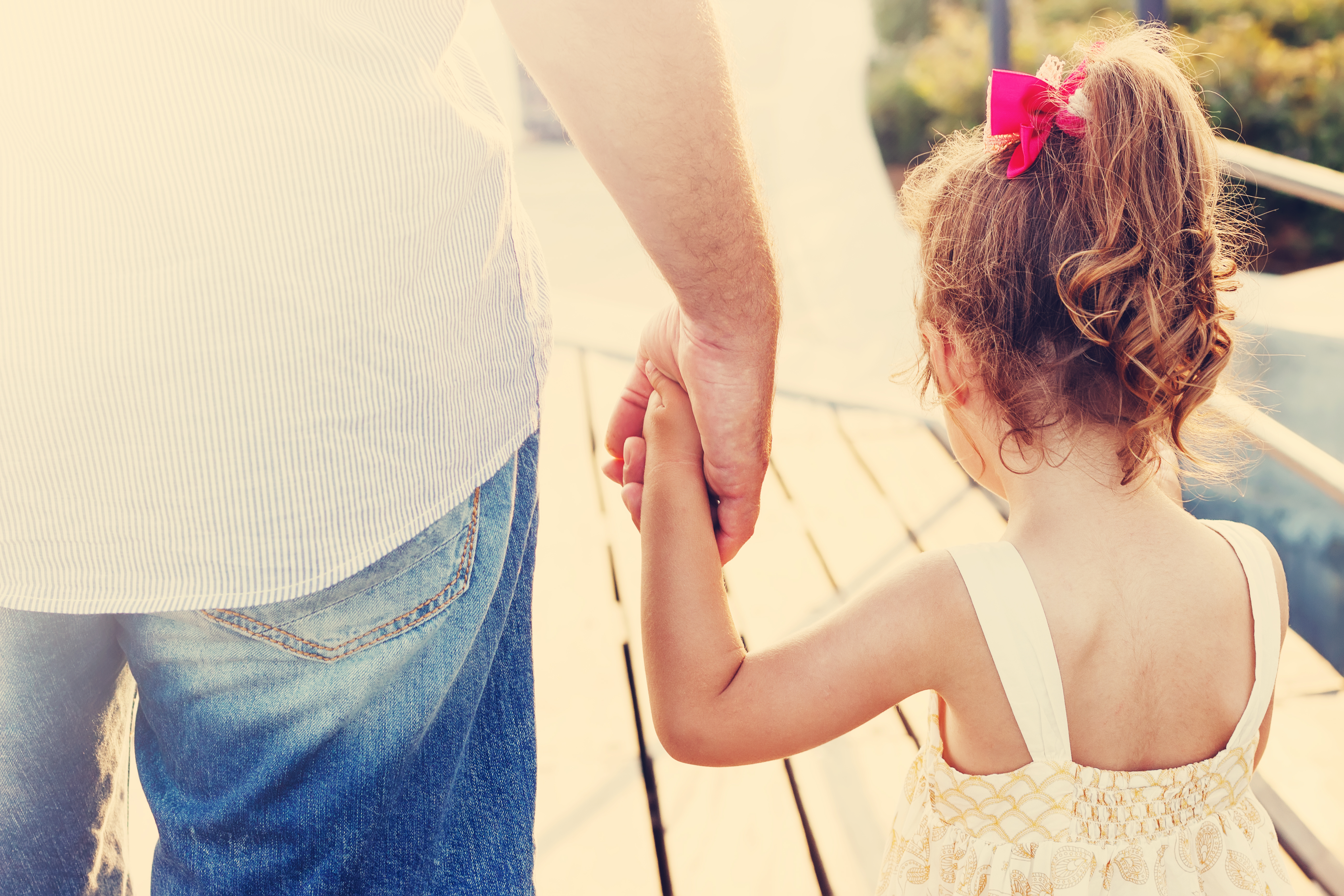 Un père et sa fille se tenant par la main | Source : Shutterstock