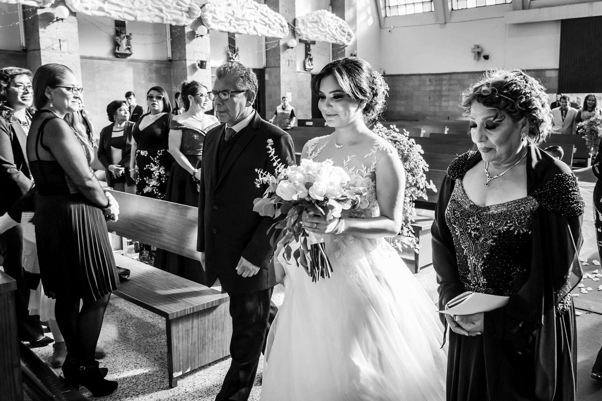 Photo en niveaux de gris d'une mariée ravie descendant l'allée | Source : Pexels