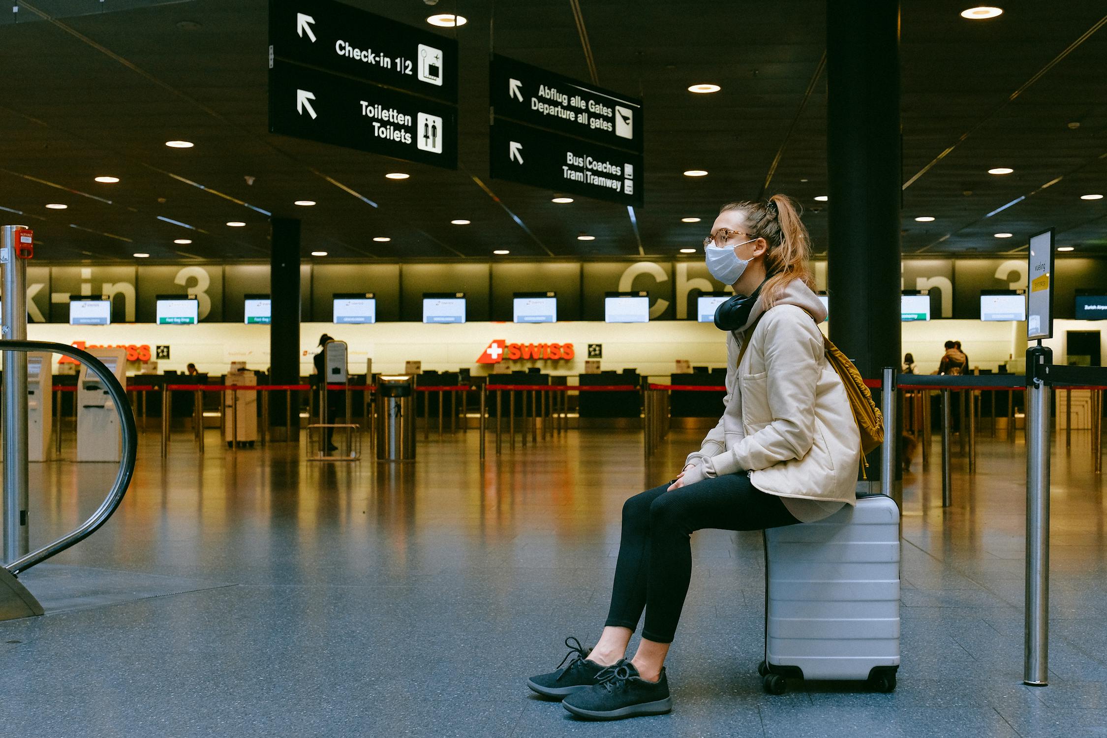 Une femme assise sur une valise | Source : Pexels