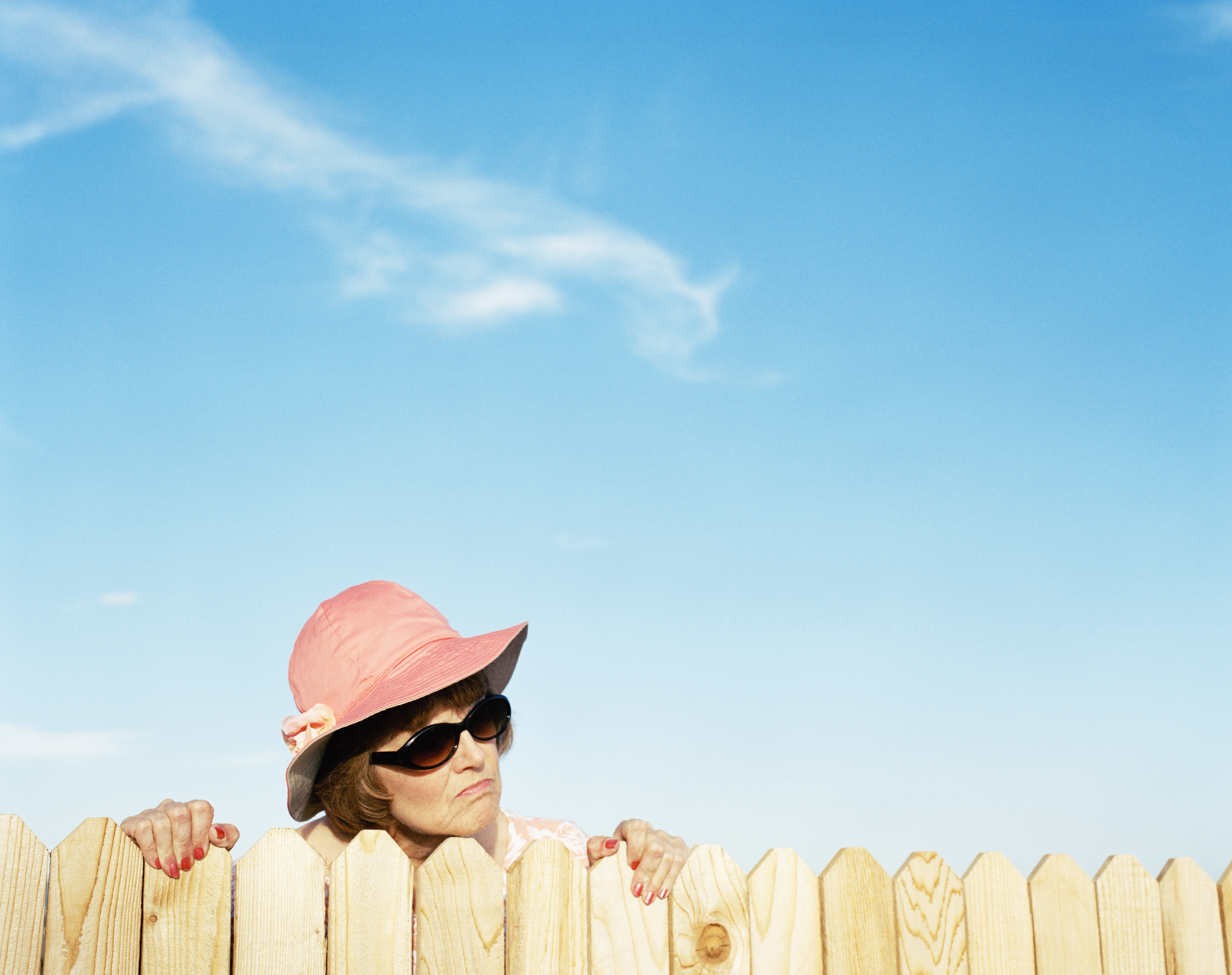 Une femme d'âge mûr qui regarde par-dessus la clôture | Source : Getty Images
