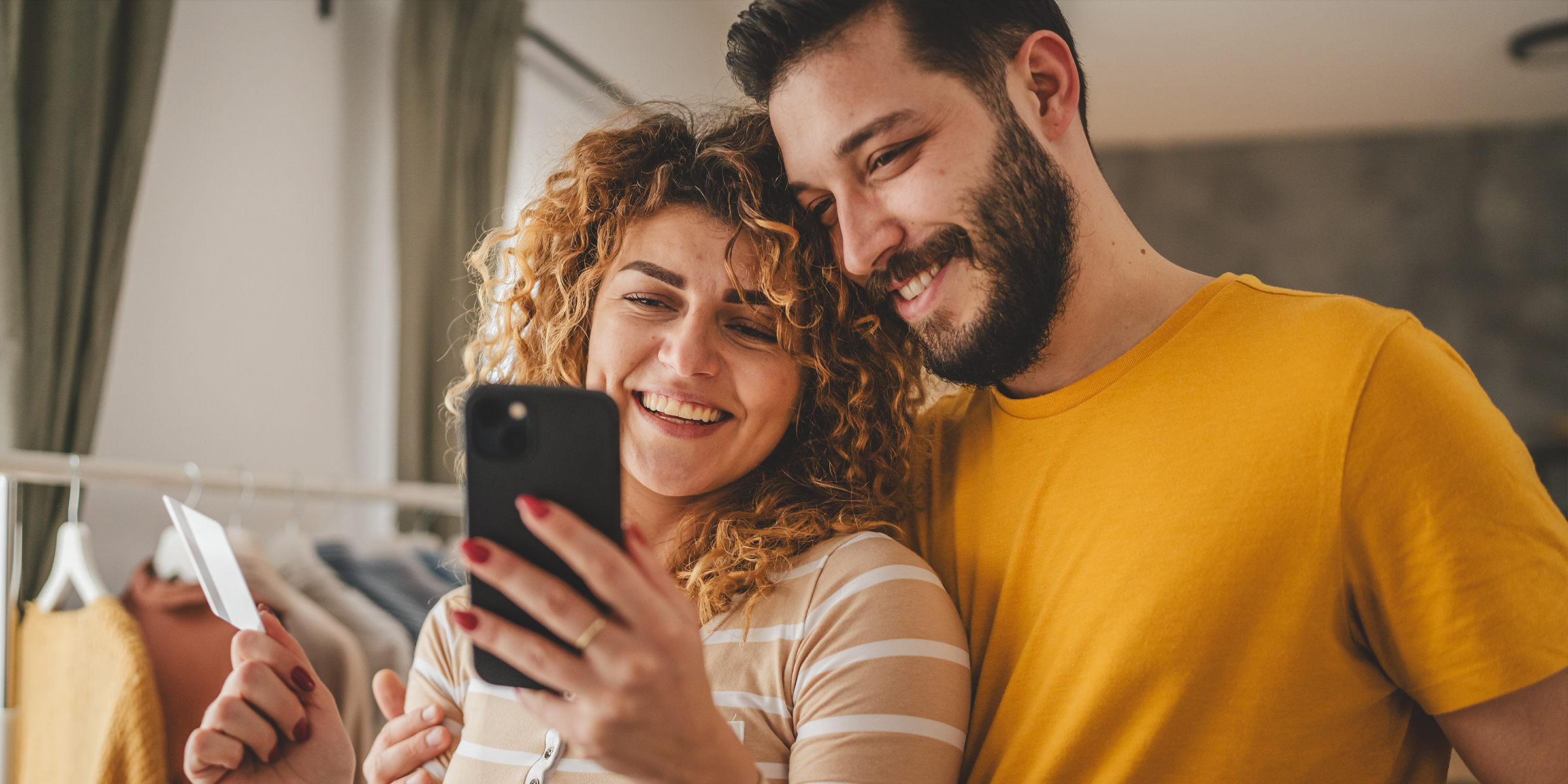 Un couple souriant devant un téléphone | Source : Shutterstock