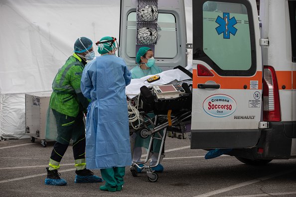 Le personnel médical transporte le premier patient touché par COVID-19 vers une tente de l'USI, en Italie | Photo : Getty Images