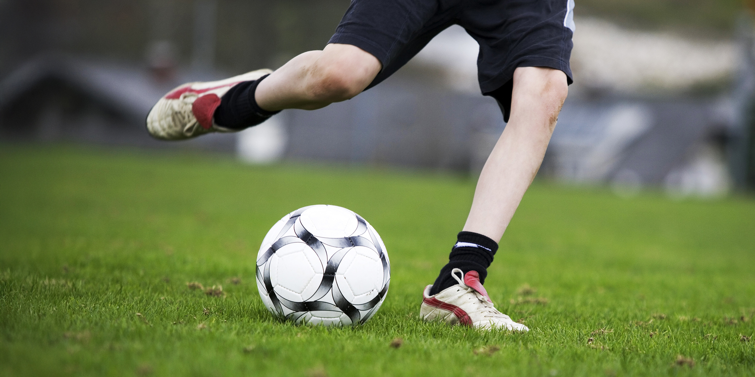 Un garçon (12-13 ans) joue au football I Source : Getty Images