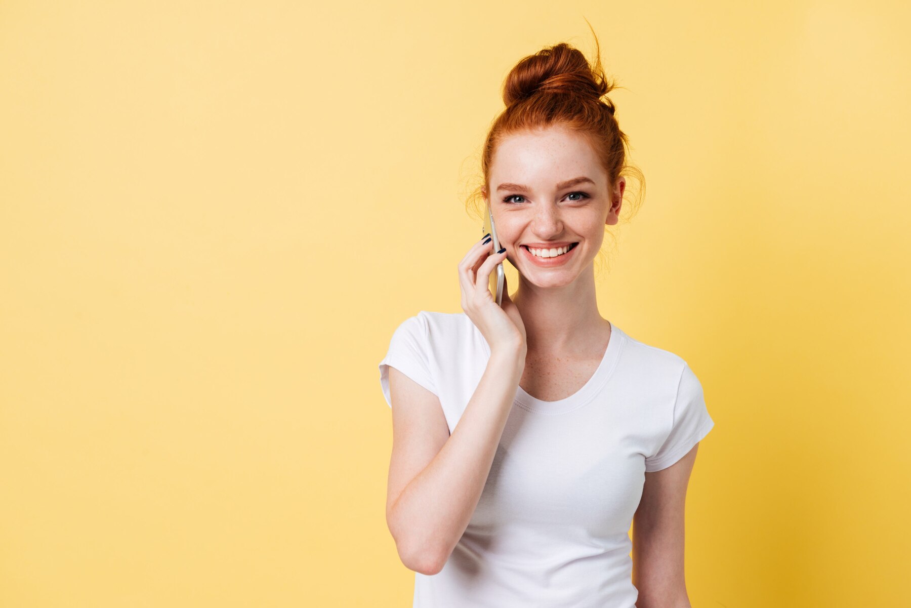 Une femme rousse qui parle au téléphone | Source : Freepik