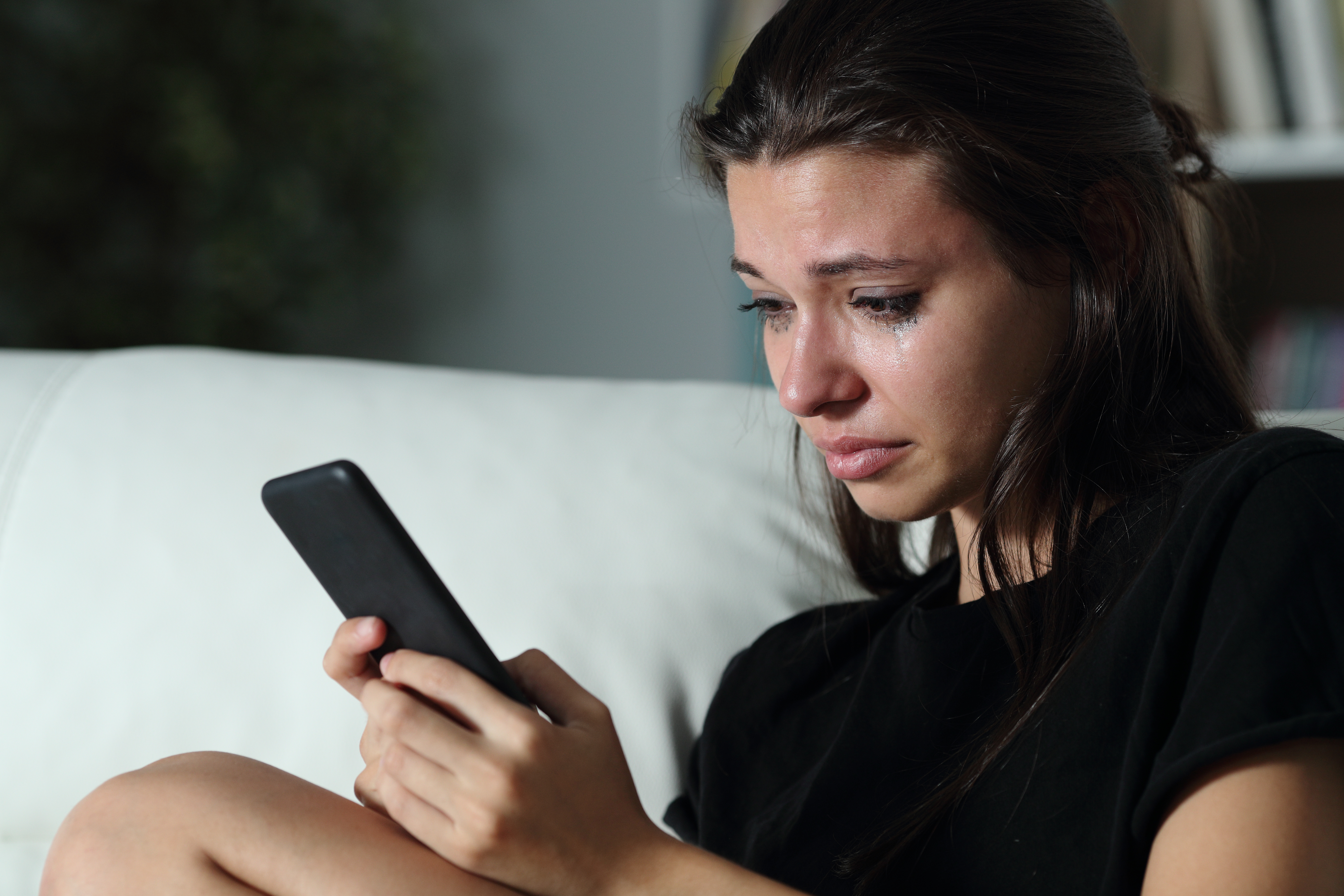 Une fille regarde son téléphone en pleurant | Source : Shutterstock