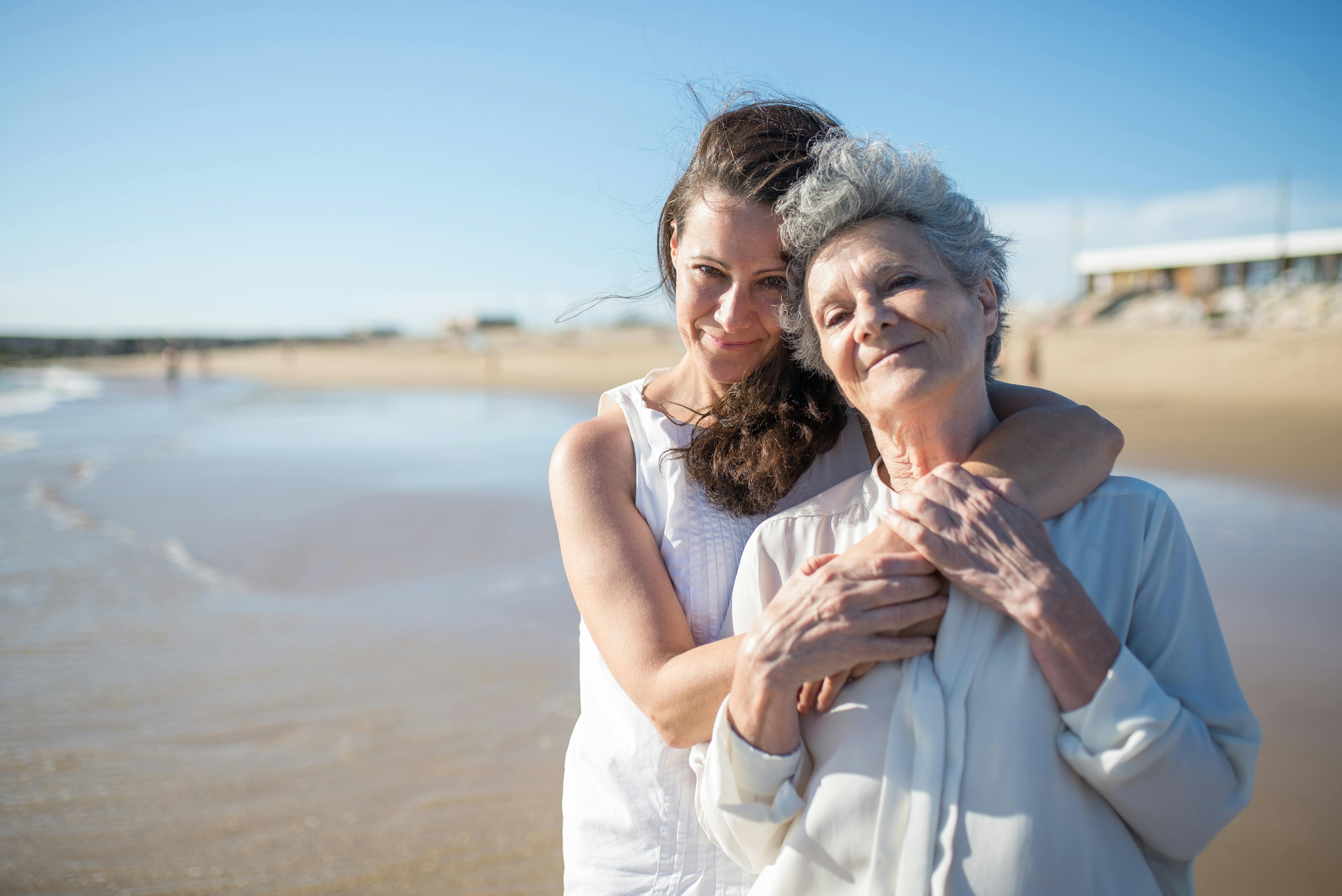 Deux femmes heureuses s'embrassant sur le bord d'une plage | Source : Pexels