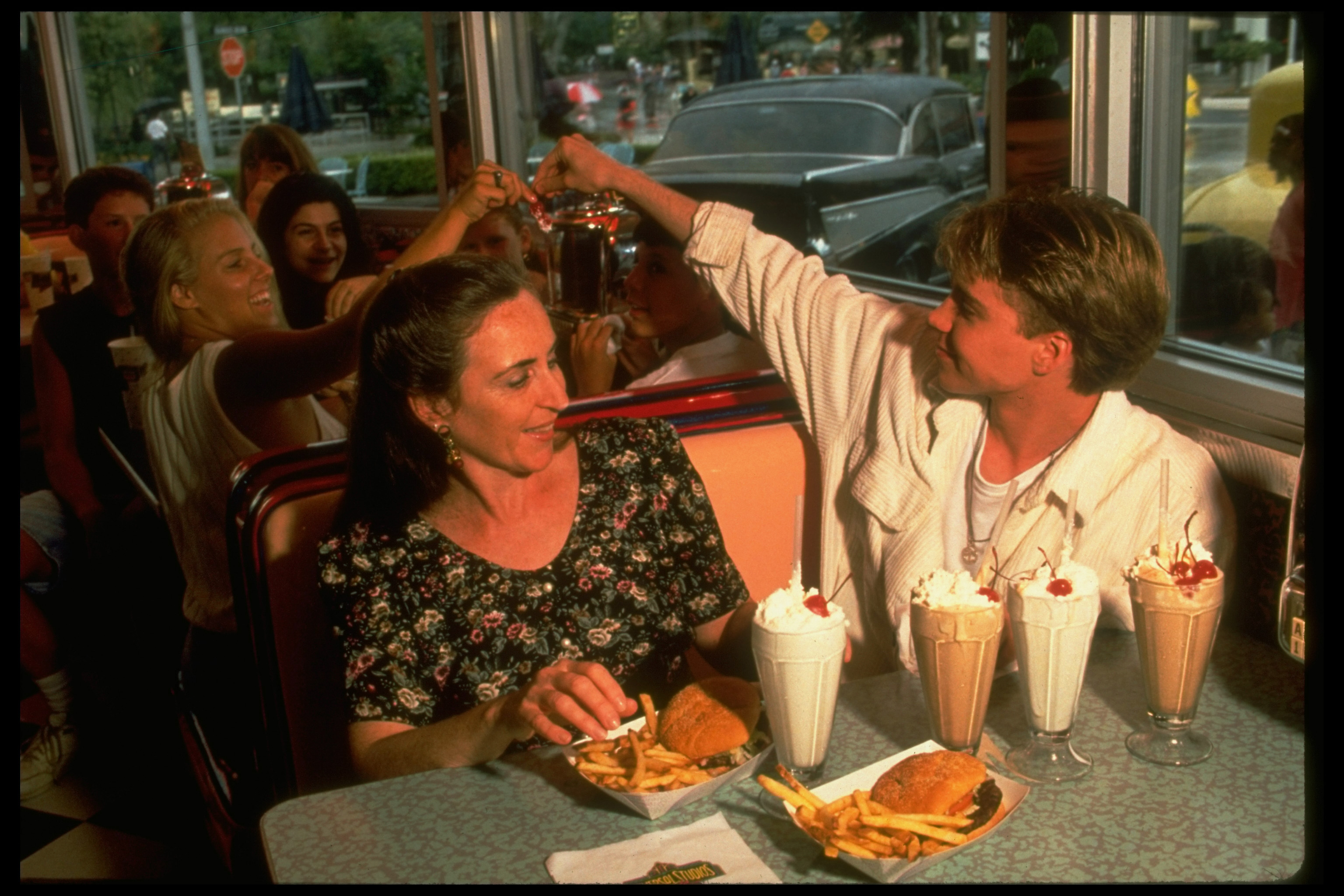 L'idole des jeunes remet un souvenir à un fan alors qu'il dîne avec sa mère en 1994 | Source : Getty Images