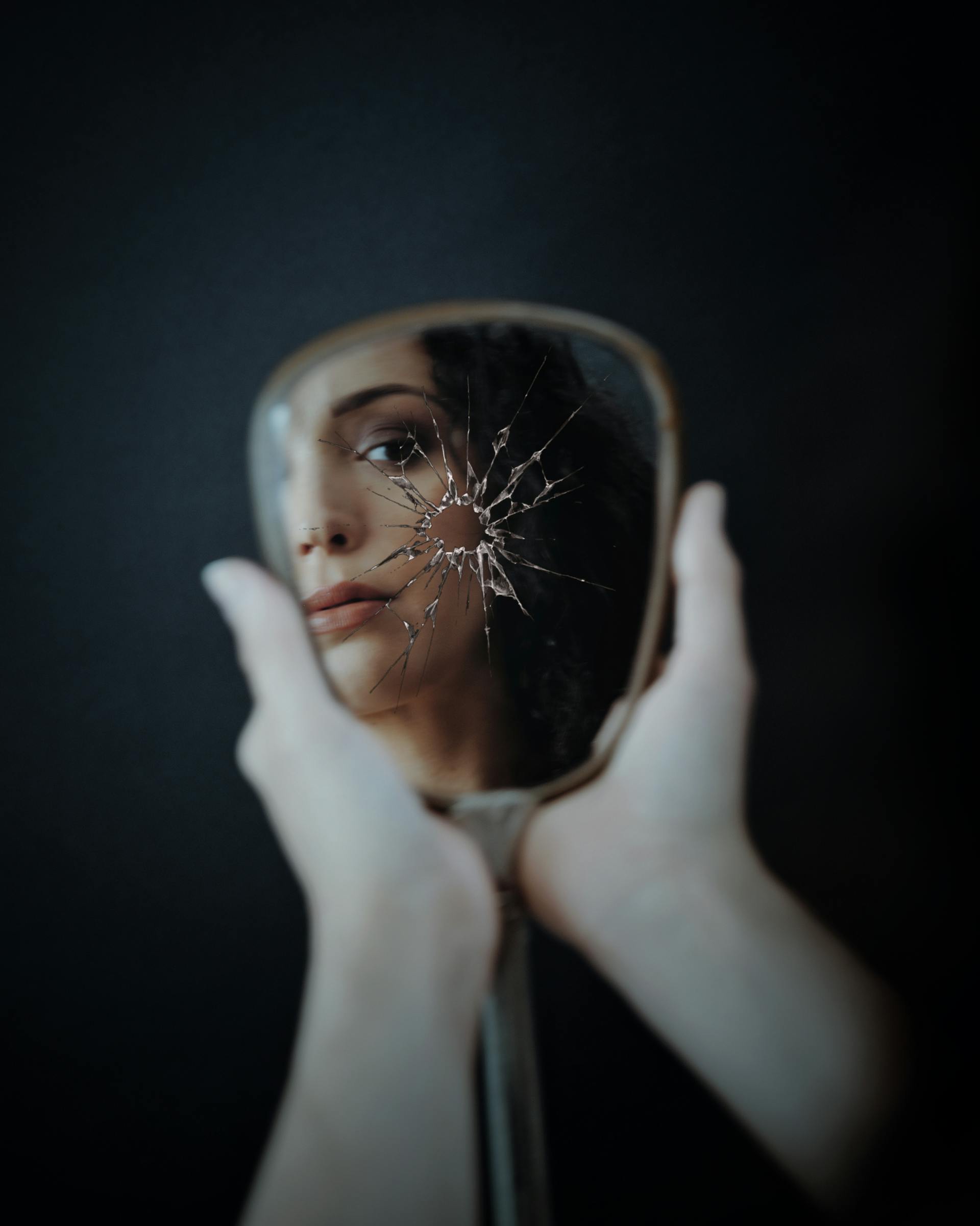 Une femme qui regarde son reflet dans un miroir brisé | Source : Pexels