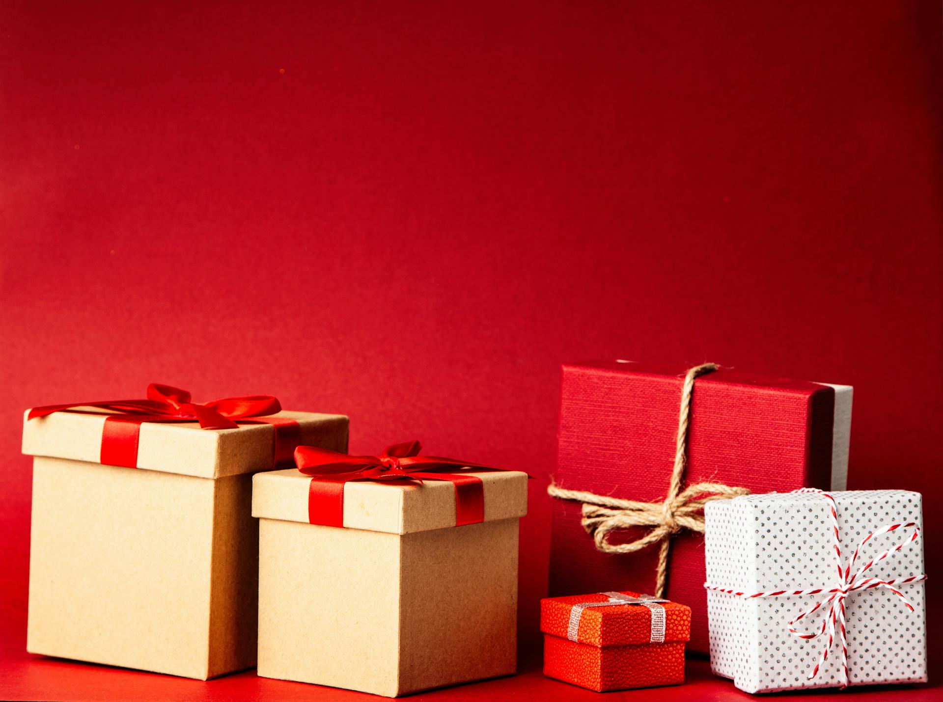 Une collection de boîtes cadeaux sur fond rouge | Source : Pexels