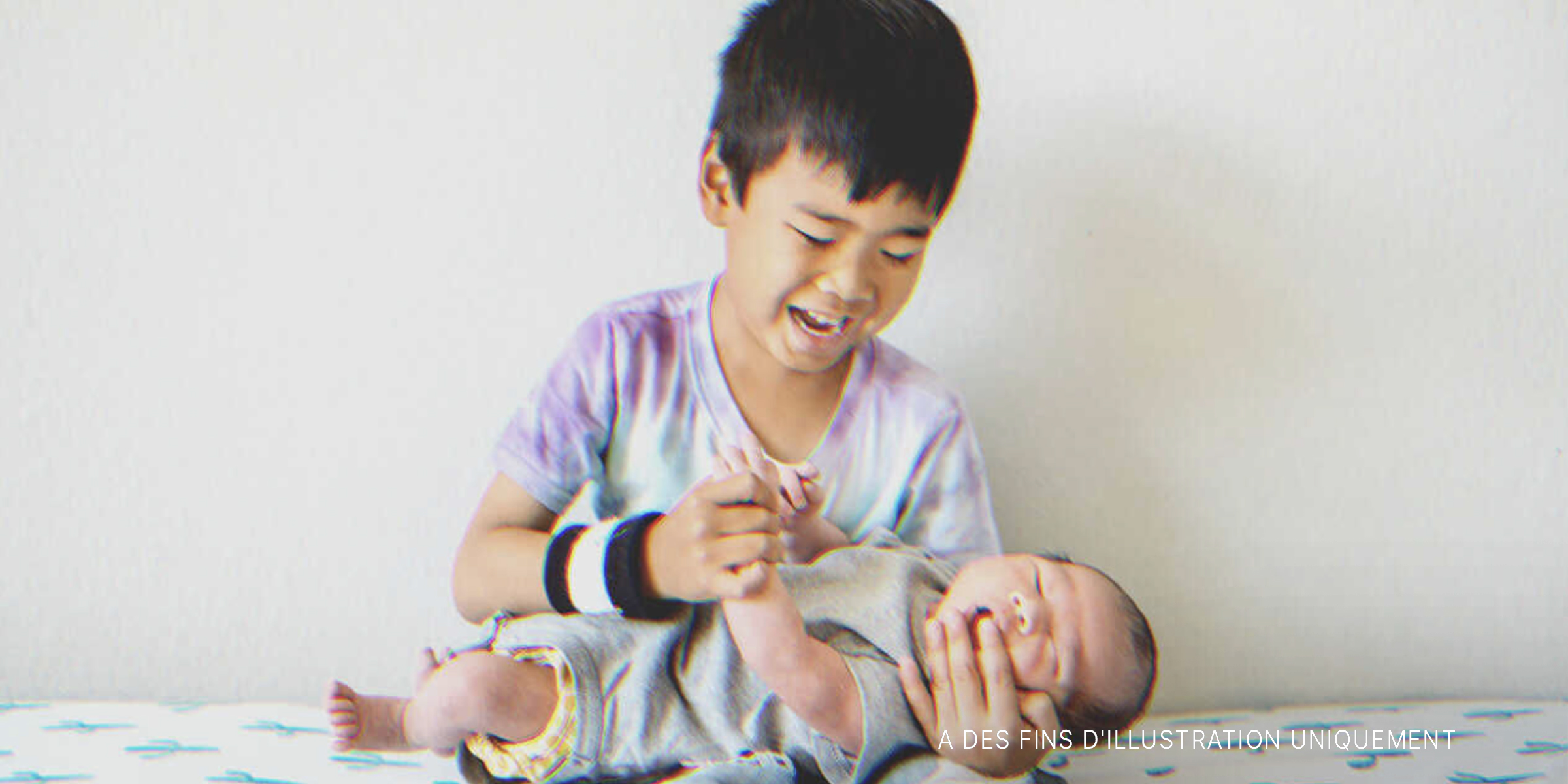 Un garçon tient un bébé | Source : Shutterstock
