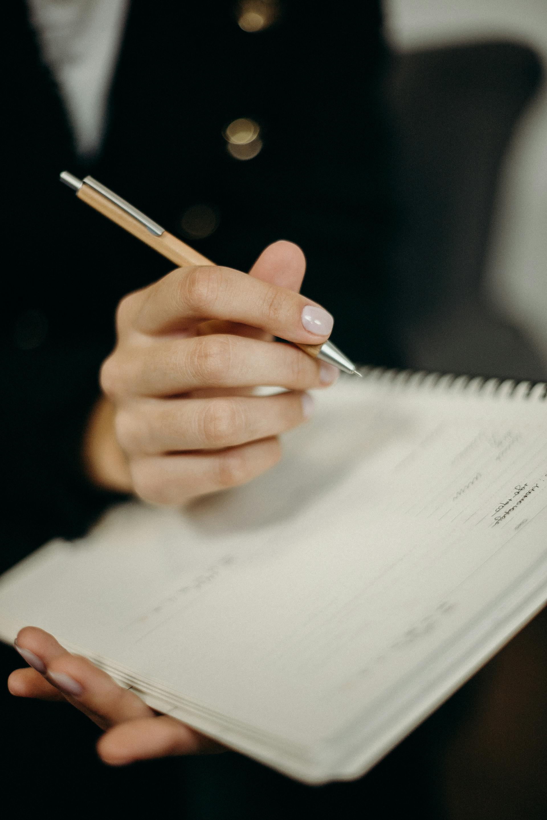 Une femme qui écrit dans un cahier | Source : Pexels