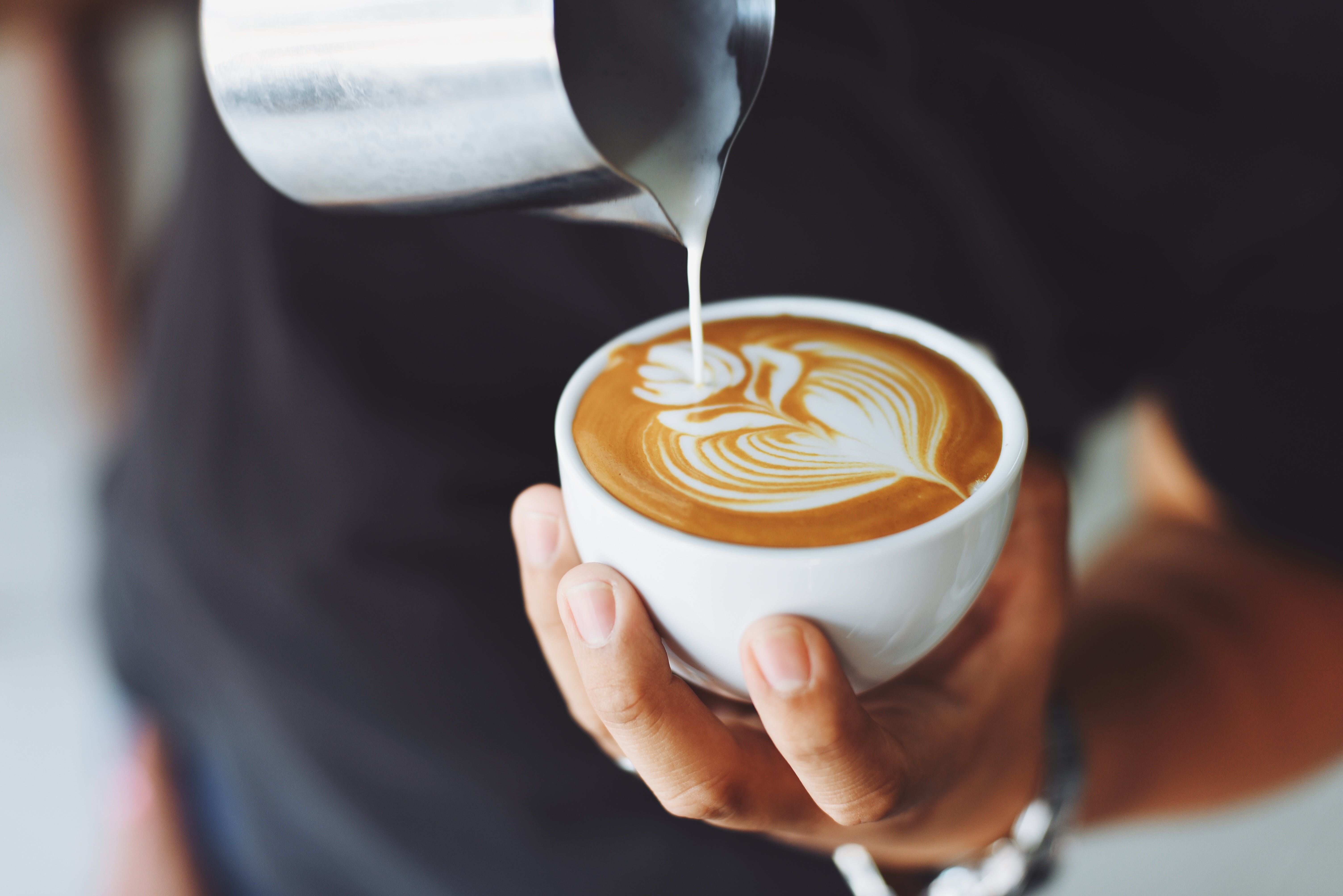 Une personne tenant une tasse de café au lait. | Source : Pexels